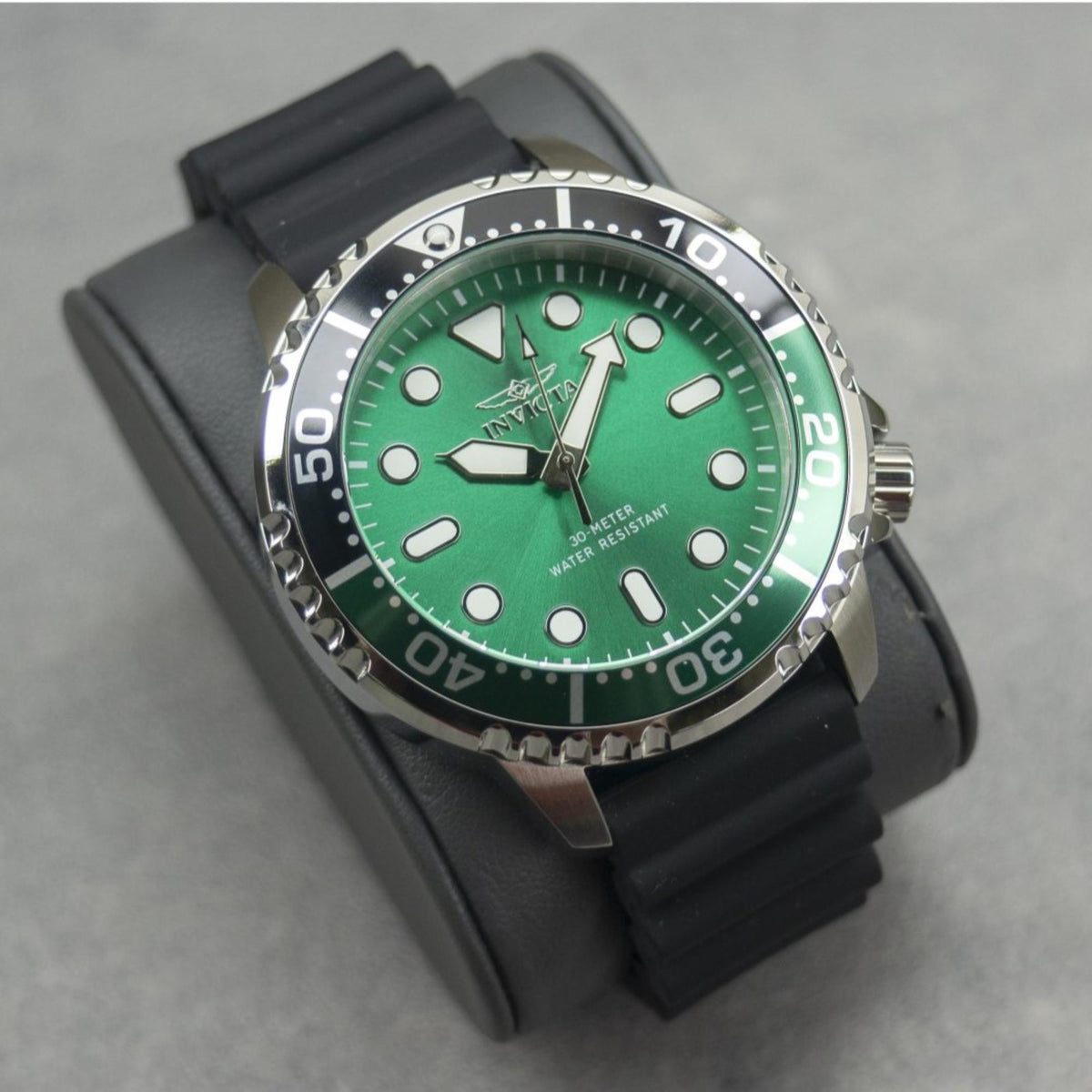 Men's dive watch three-quarter view: green dial, stainless bezel, black silicone strap