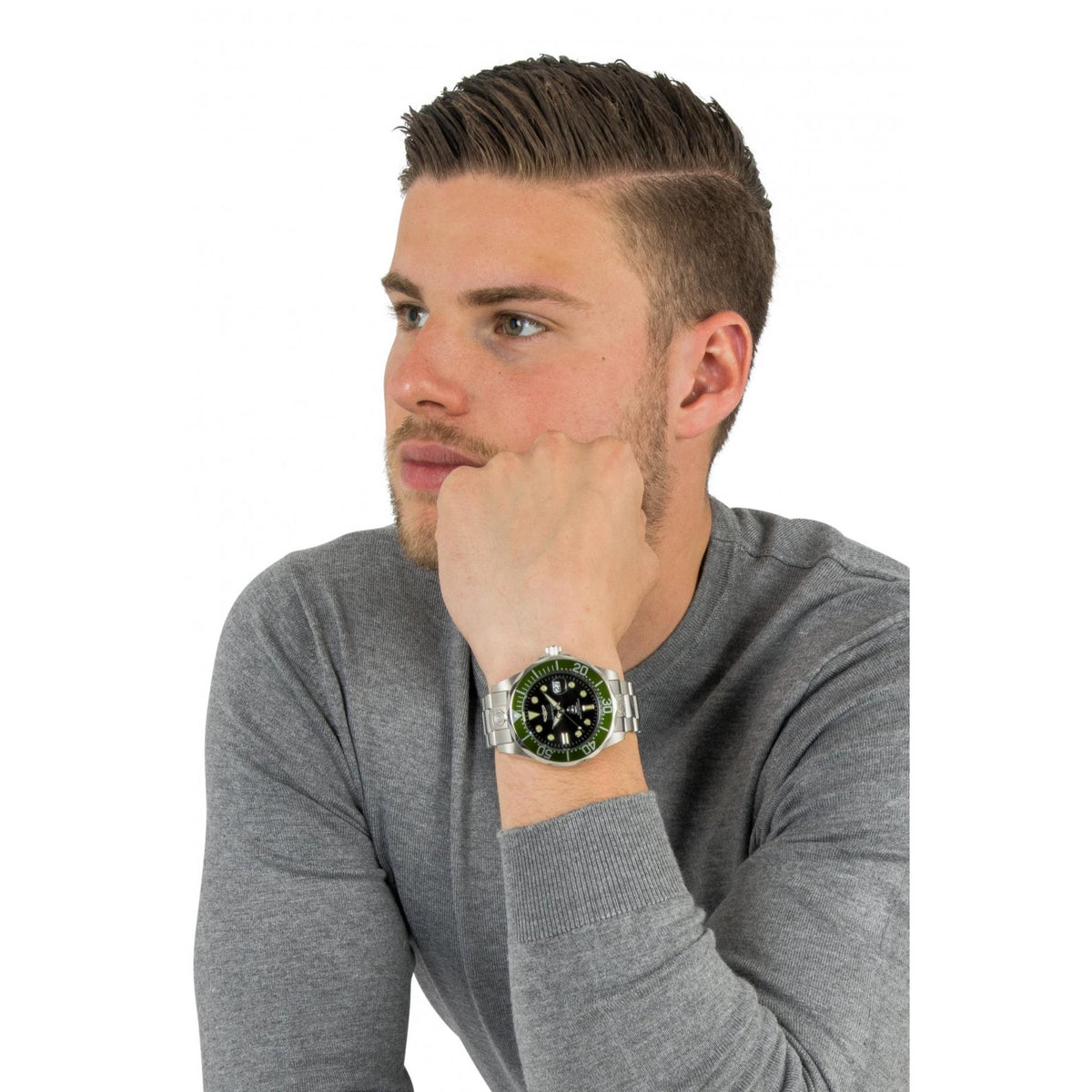 Men's steel dive watch on wrist with black dial and green bezel