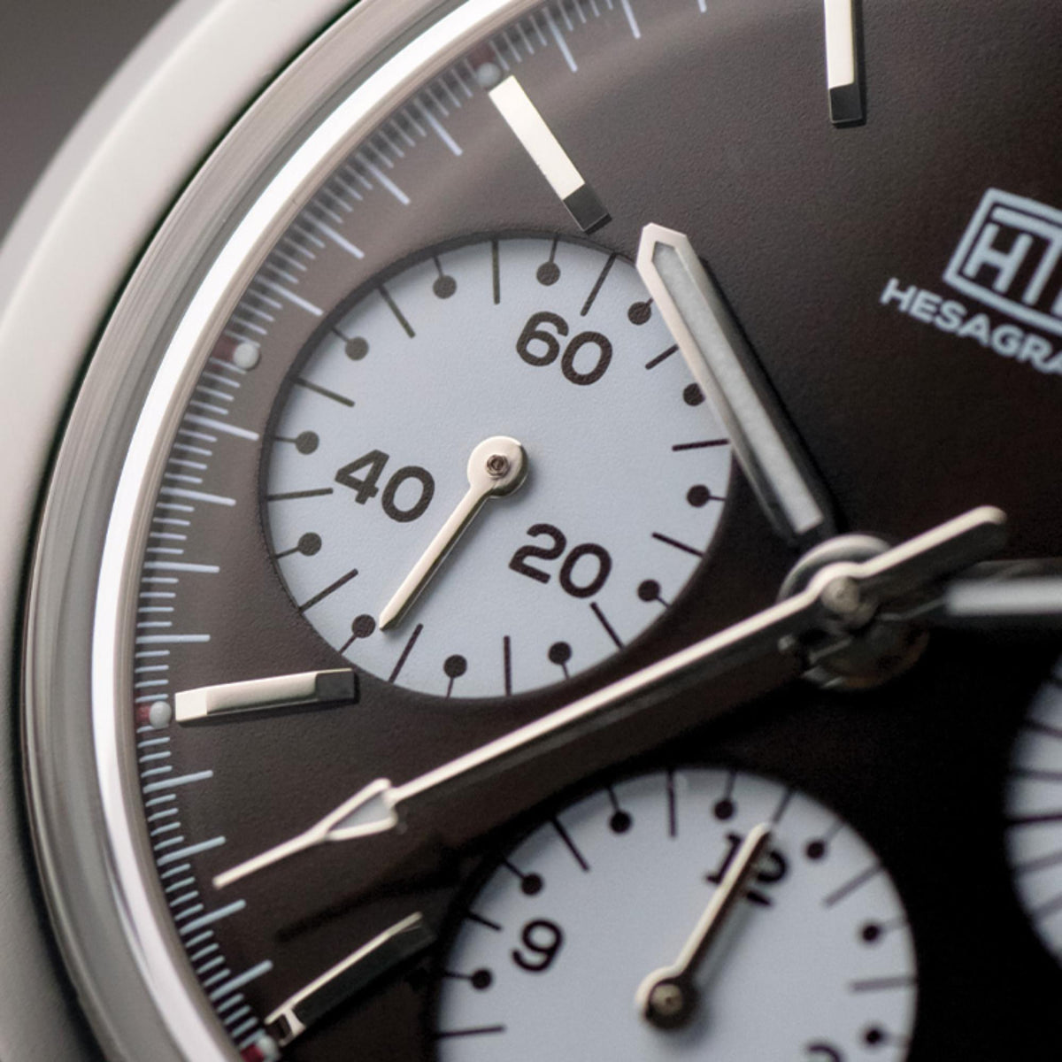 Close-up of men's chronograph watch dial with dark bezel, numbers and subdials