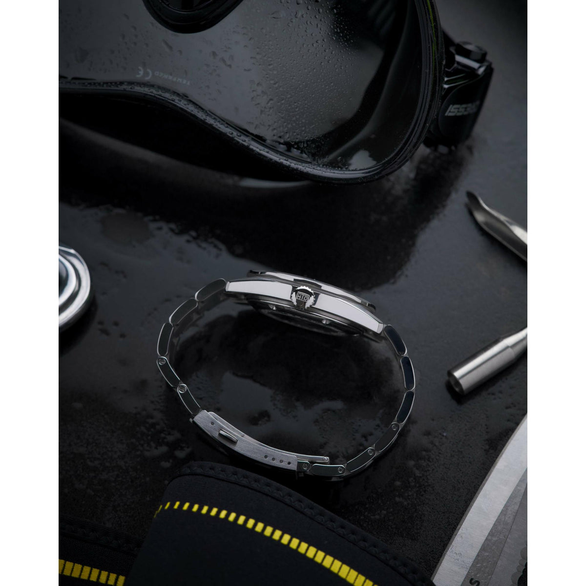 Stainless steel watch back with bracelet on dark display surface
