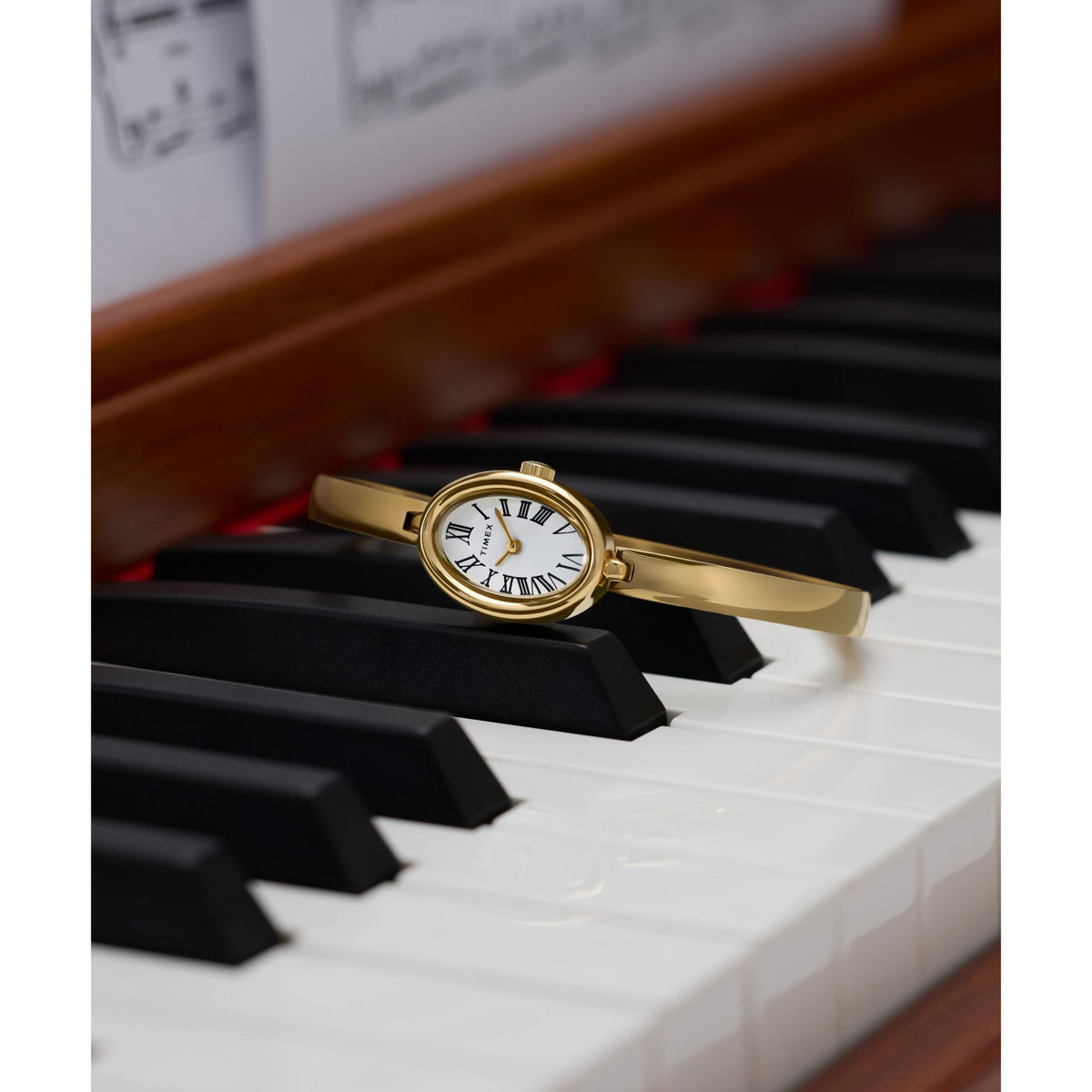 Gold-tone ladies quartz wrist watch with white dial and Roman numeral markers