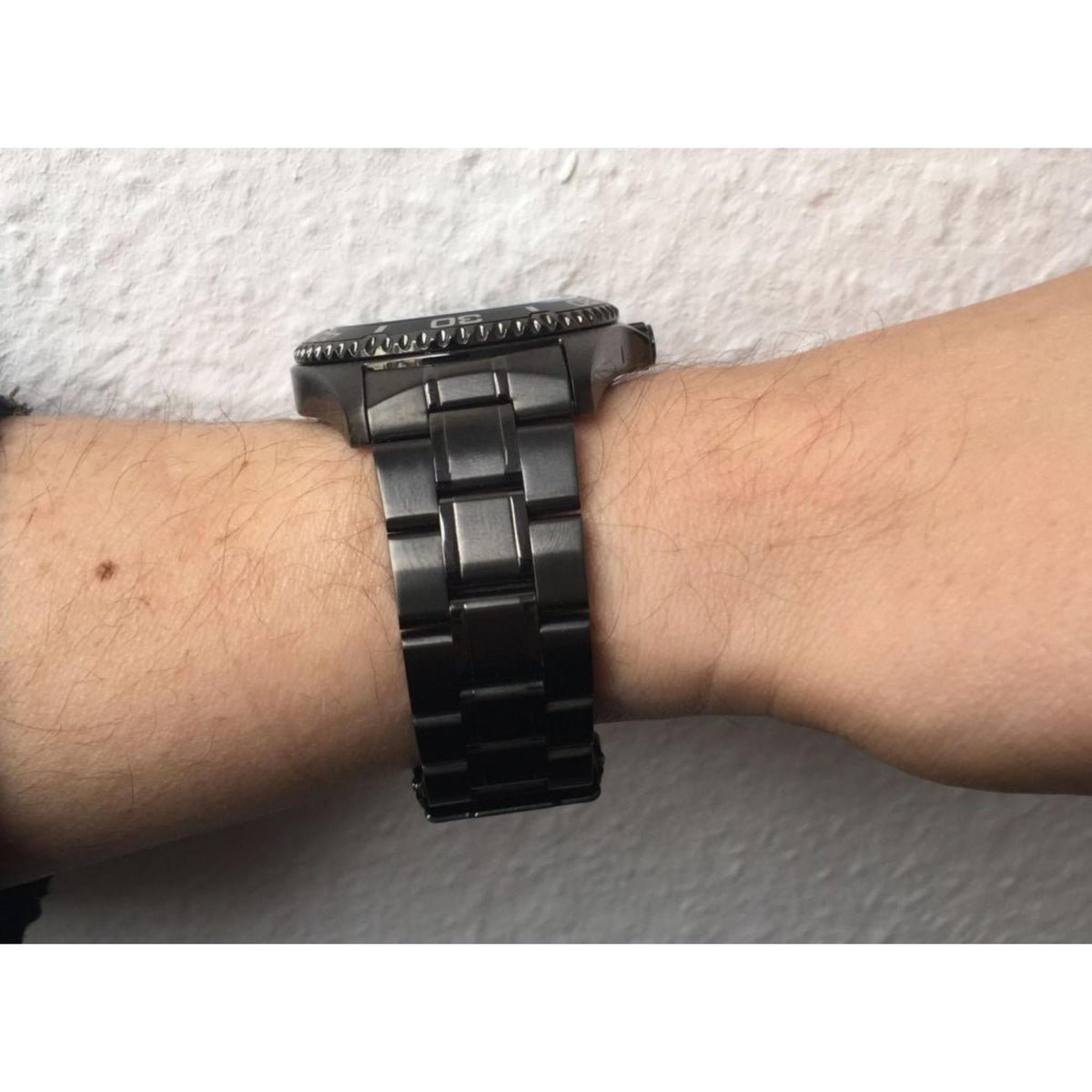 Men's automatic watch on wrist with black steel link bracelet
