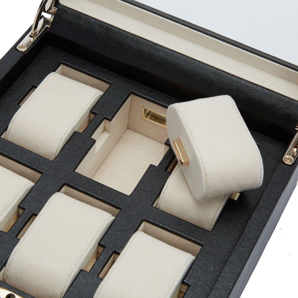 Interior view of a black watch box with six cream watch holders and dividers