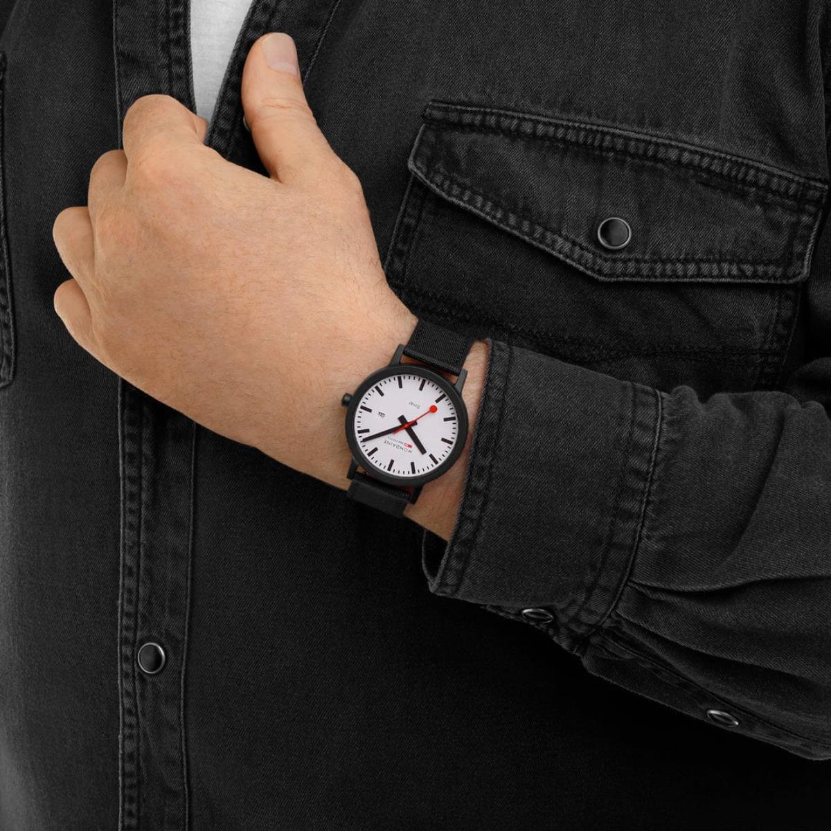 Mondaine Essence MS1.41910.LB 41mm solar-powered wristwatch worn on wrist over a black denim shirt