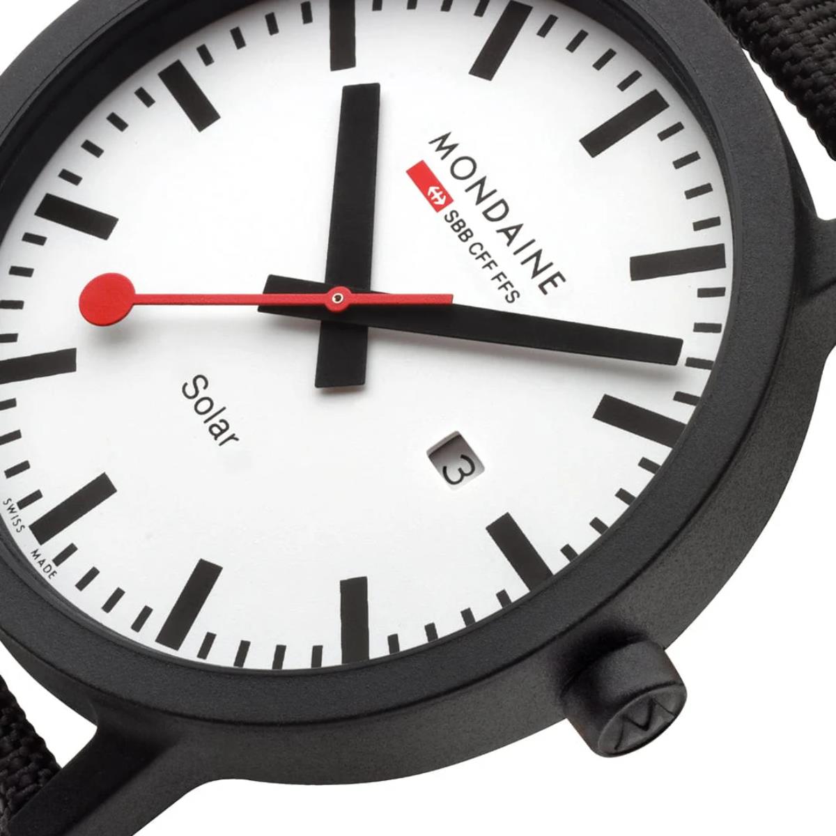Close-up macro detail of Mondaine Essence MS1.41910.LB dial showing solar text, date aperture, and red second hand