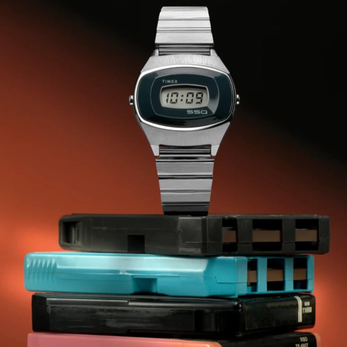 Digital steel watch with blue LCD on display, with stacked spare bands