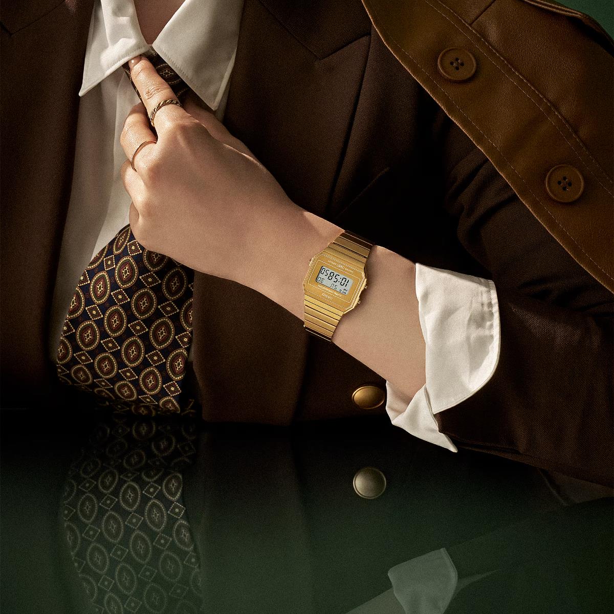 Casio Vintage Iconic A700WEVG-9AEF gold digital watch styled on wrist with brown suit