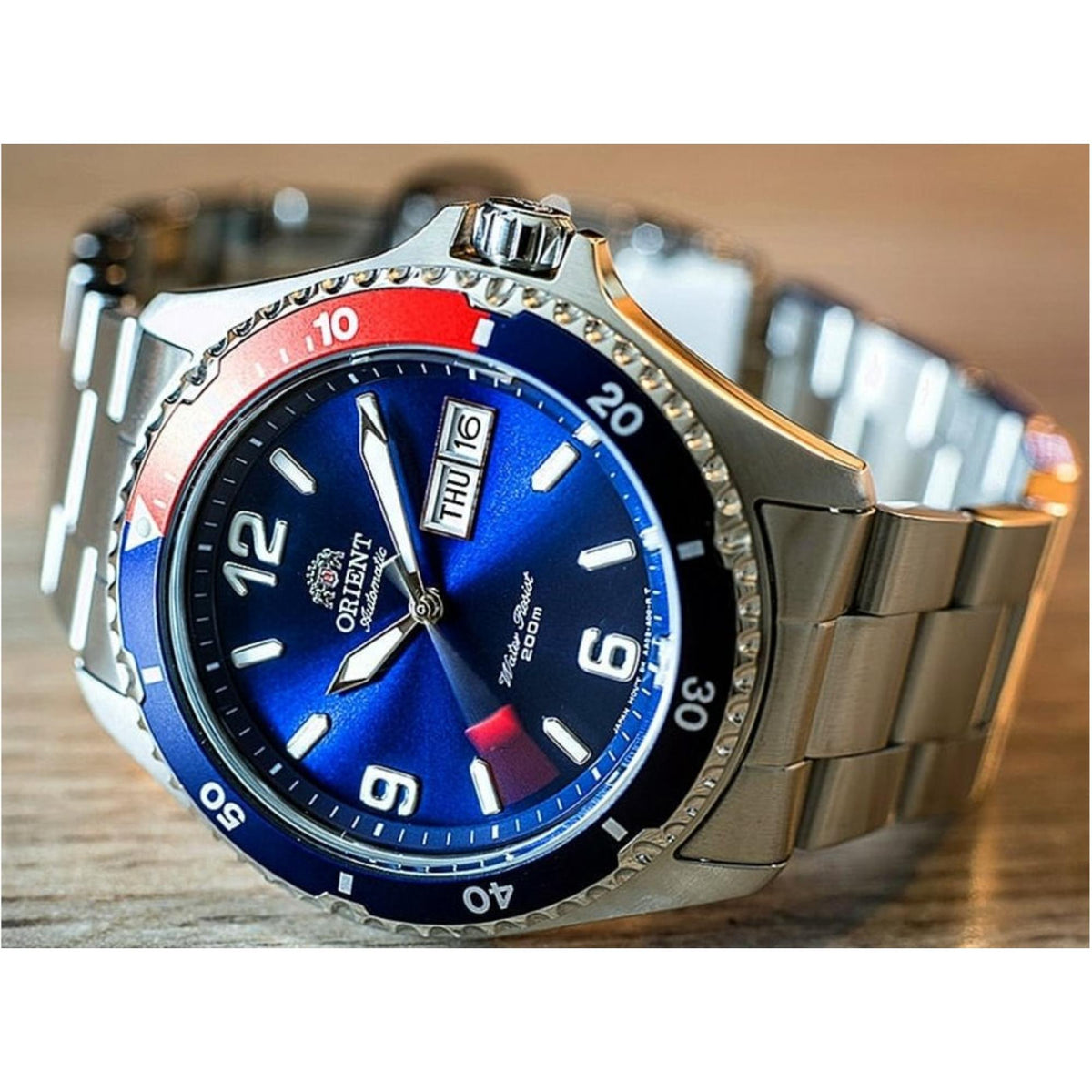 Men's automatic watch with blue dial, red bezel insert, steel bracelet and bezel