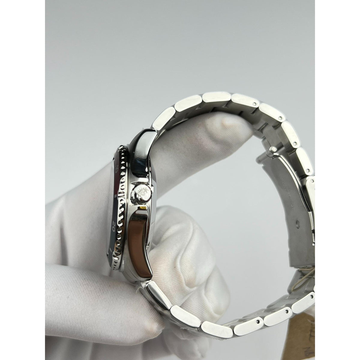Steel automatic watch with crown, bracelet links, and bezel edge in side view