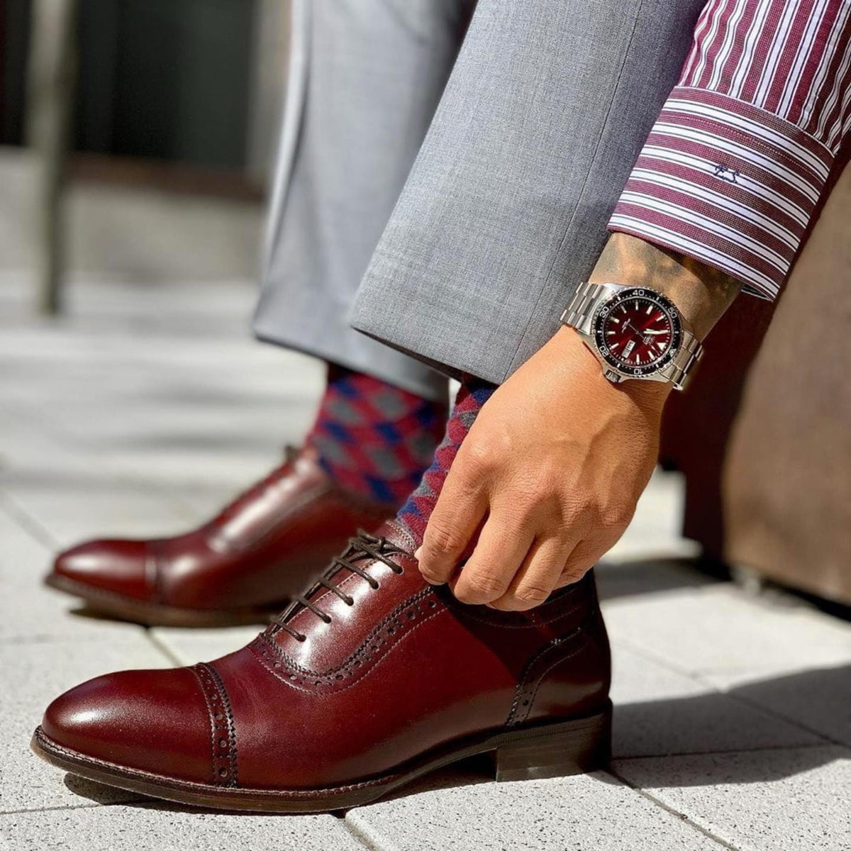 Orient Mako RA-AA0003R39B mens wrist watch styled on wrist featuring a red dial and stainless steel bracelet