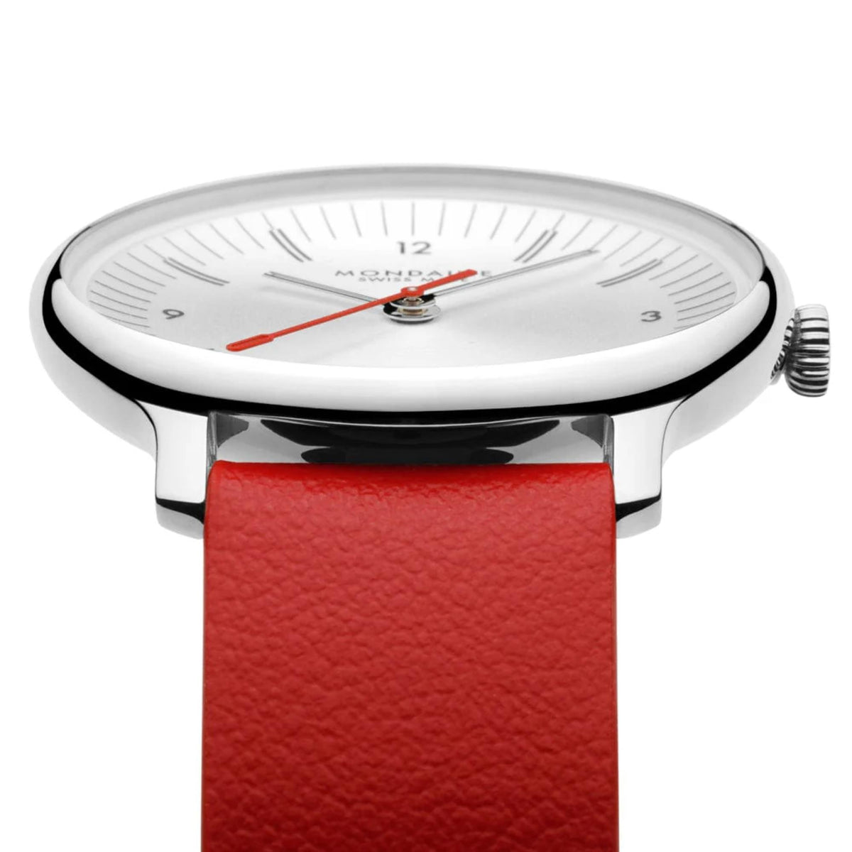 Close-up of Mondaine watch face, focusing on the polished silver-tone bezel, thin baton hour indices, and the red second hand against the metallic white dial