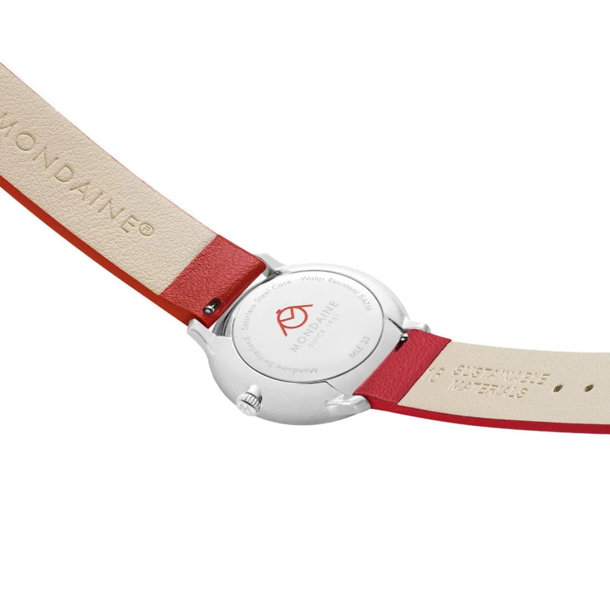Close-up of the Mondaine Doppio watch's silver-tone caseback, showing the red Mondaine logo, engraving details, and the inner lining of the red strap marked with 'Sustainable Materials'