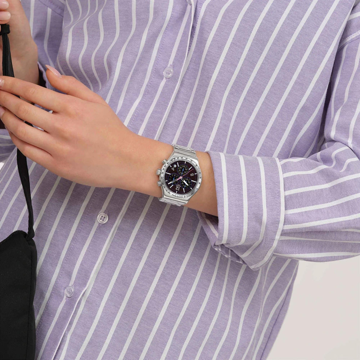Chronograph wristwatch with black dial and stainless steel bracelet on the wrist