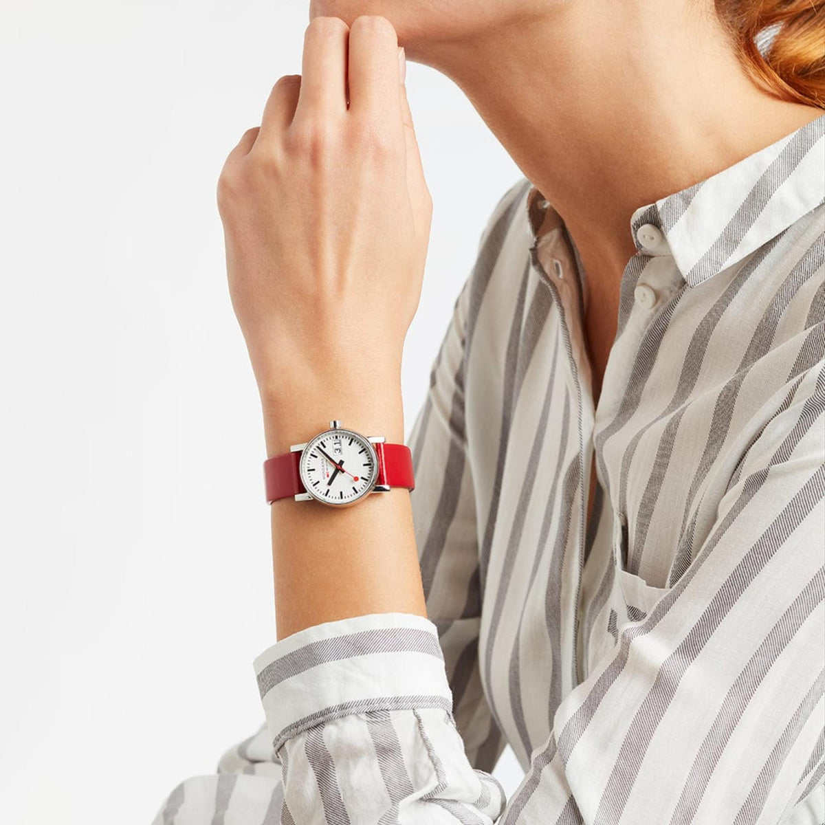 Mondaine Evo2 MSE.30210.LCV red strap watch styled on-wrist with a striped button-down shirt