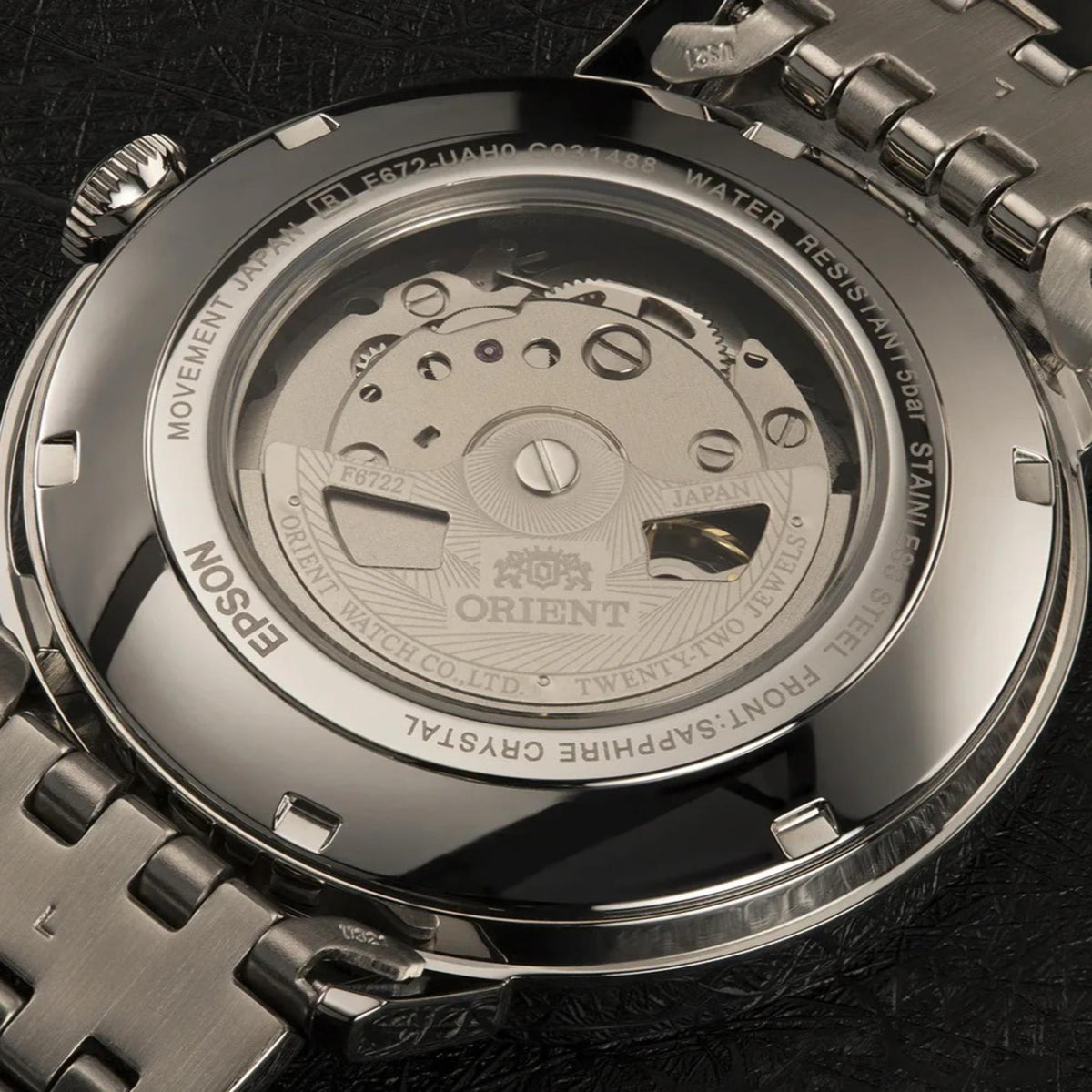 Back of stainless steel automatic watch with visible movement and ORIENT branding
