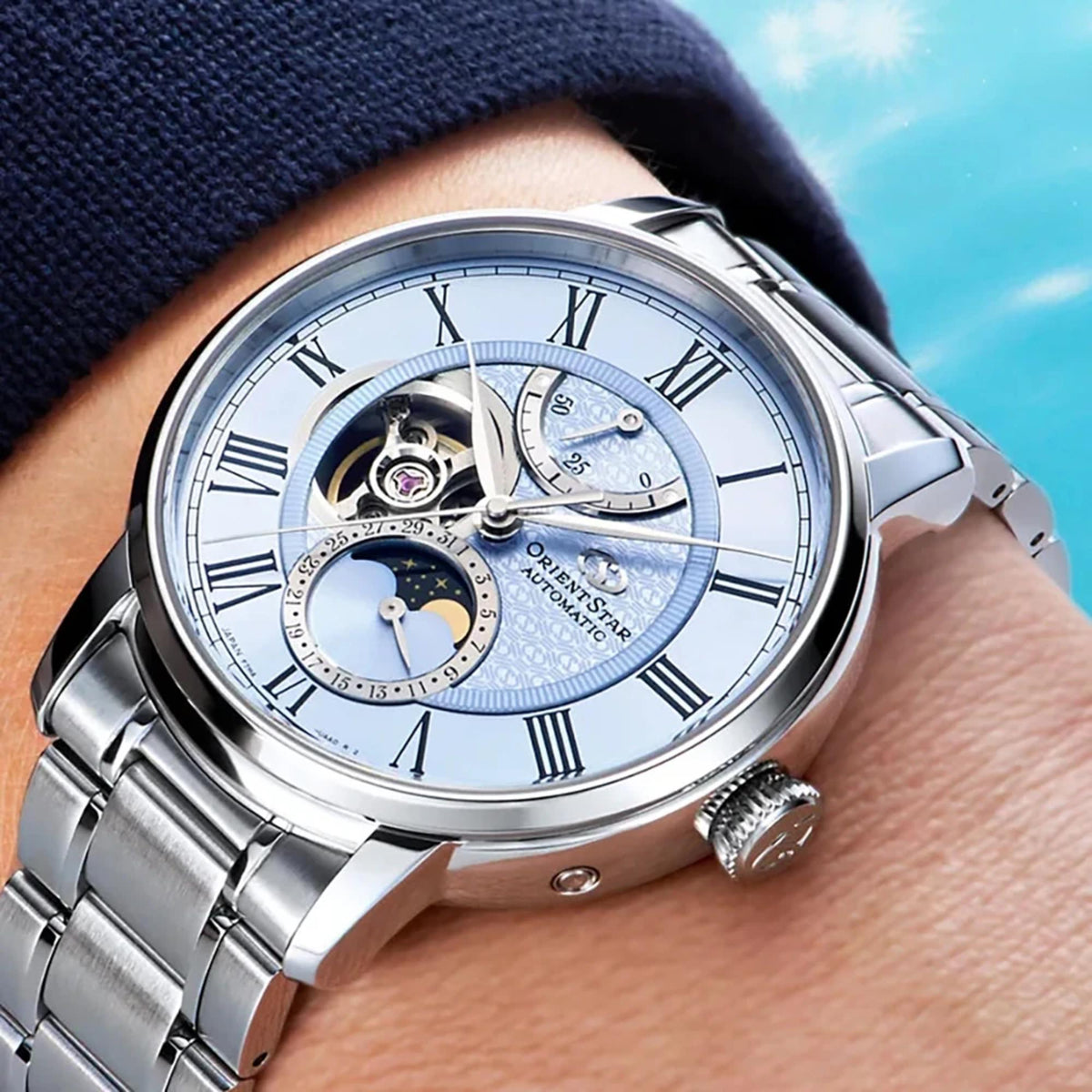 Orient Star Moon Phase RE-BT0007L00B watch worn on wrist with light blue dial and stainless steel bracelet