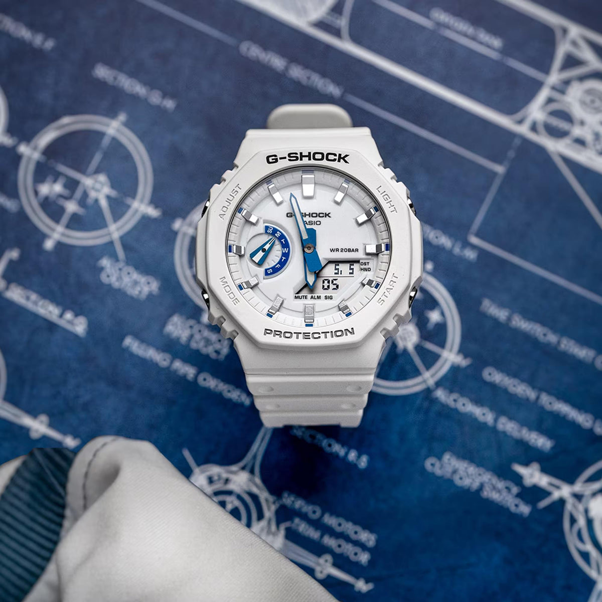 White resin G-Shock watch on wrist with blue subdial and analog hands