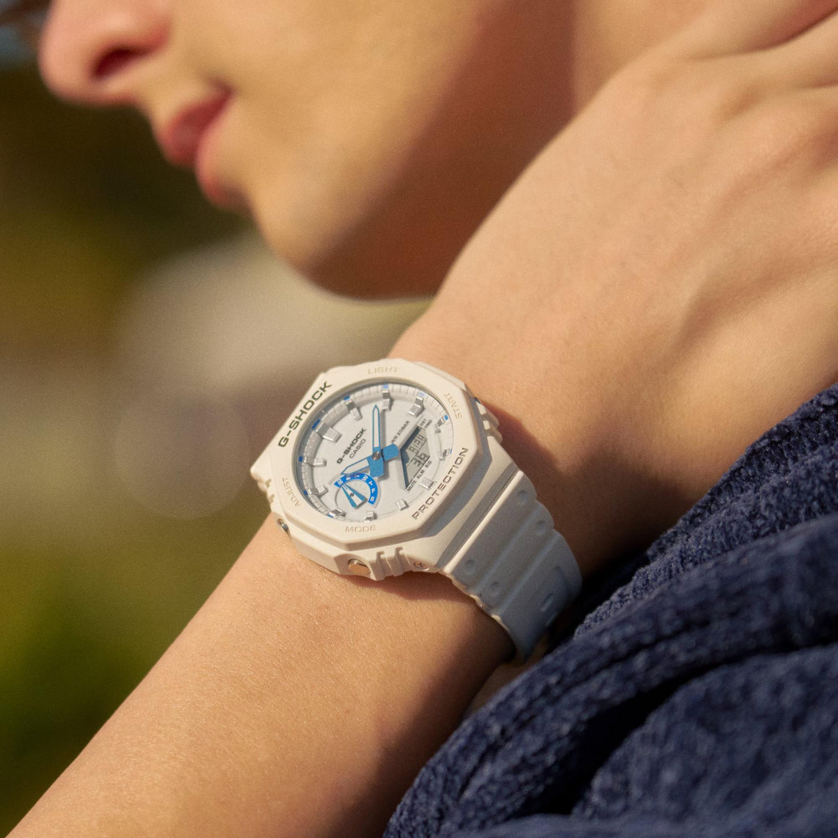 White resin G-Shock watch on wrist with blue subdial and analog hands
