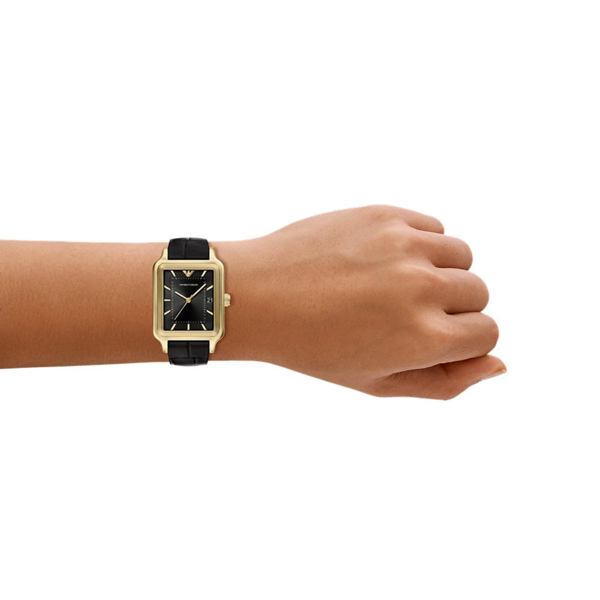 Ladies quartz wristwatch on a wrist with black dial, gold-tone case, black leather strap.