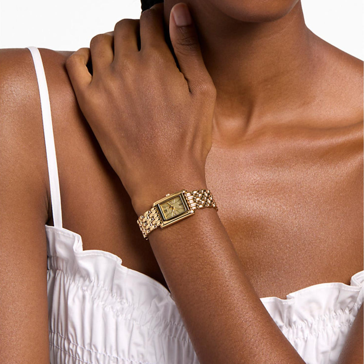 Gold-tone rectangular watch worn on wrist with steel link bracelet and square dial