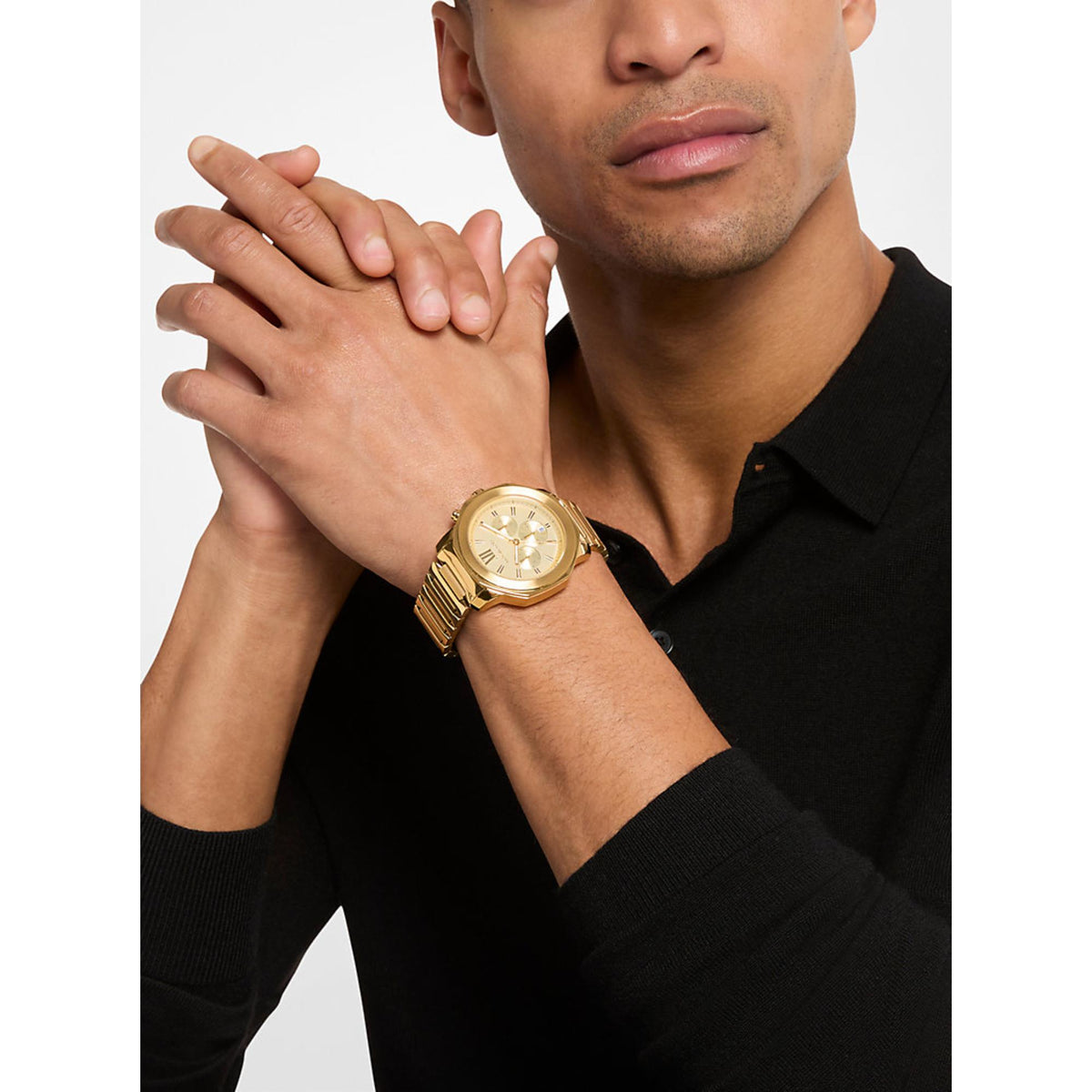 Gold-tone steel chronograph watch on man's wrist, white dial with subdials
