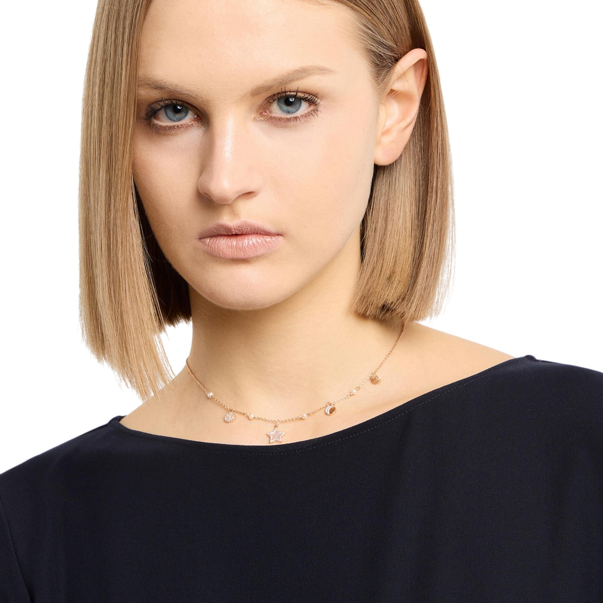 Rose gold-tone necklace on model with small star and round charm stations
