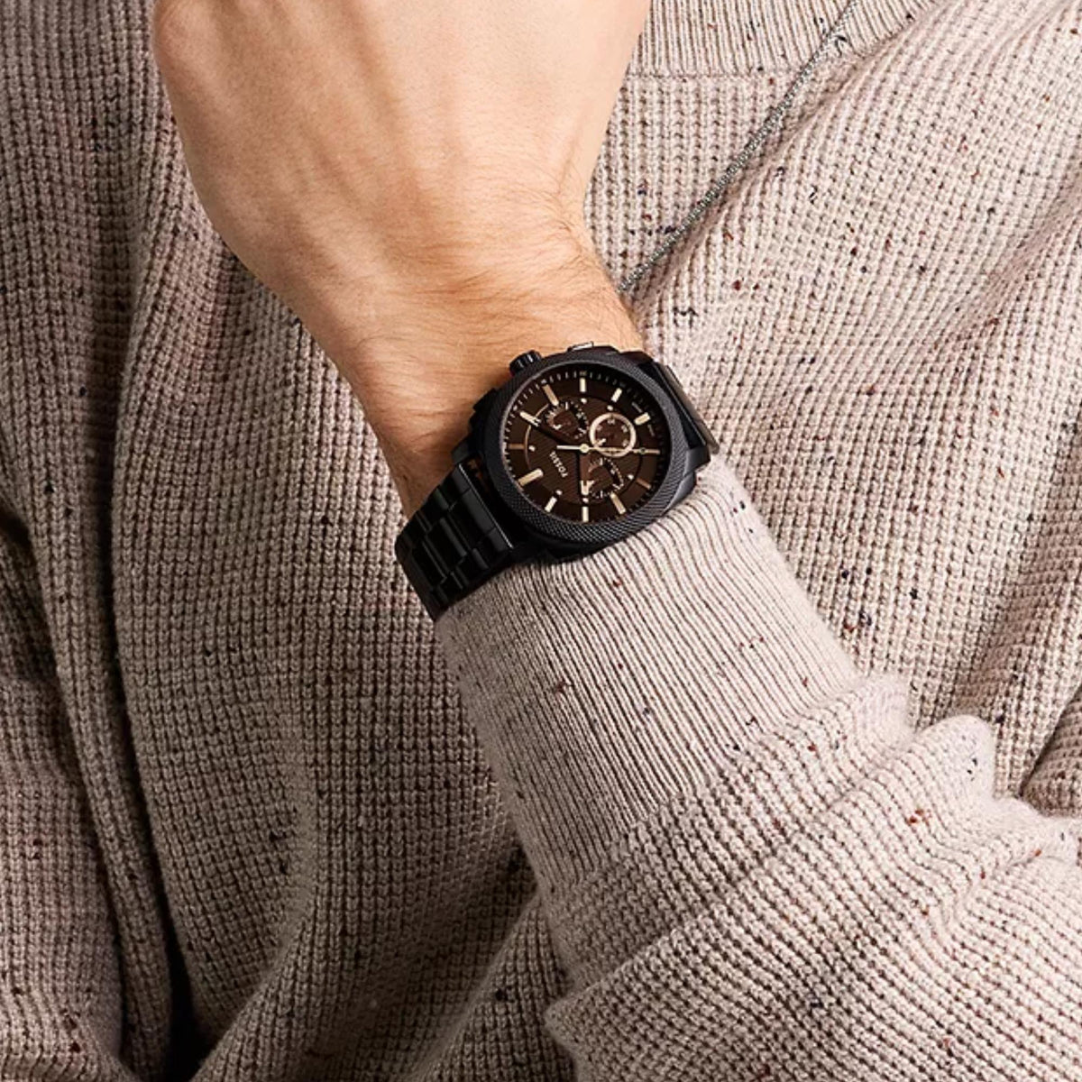 On-wrist shot of Fossil Machine FS6097 mens timepiece highlighting the black dial, textured bezel, and matching steel links