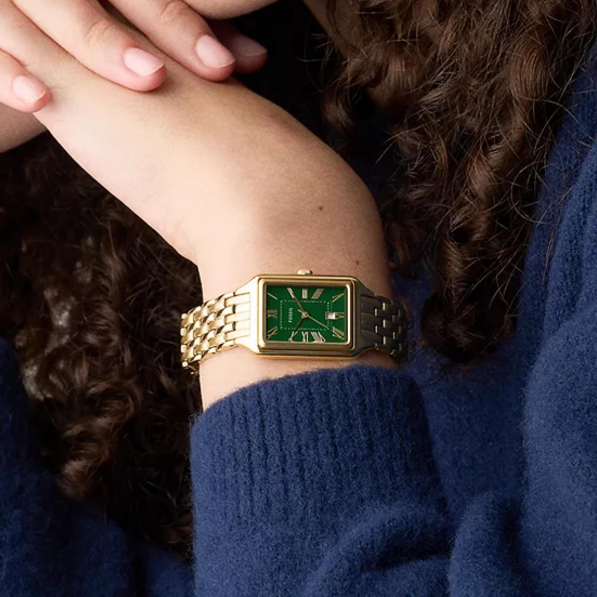 On-wrist view of the Fossil Raquel ES5452 ladies timepiece displaying the green dial and gold-tone casing styled with a navy knit top