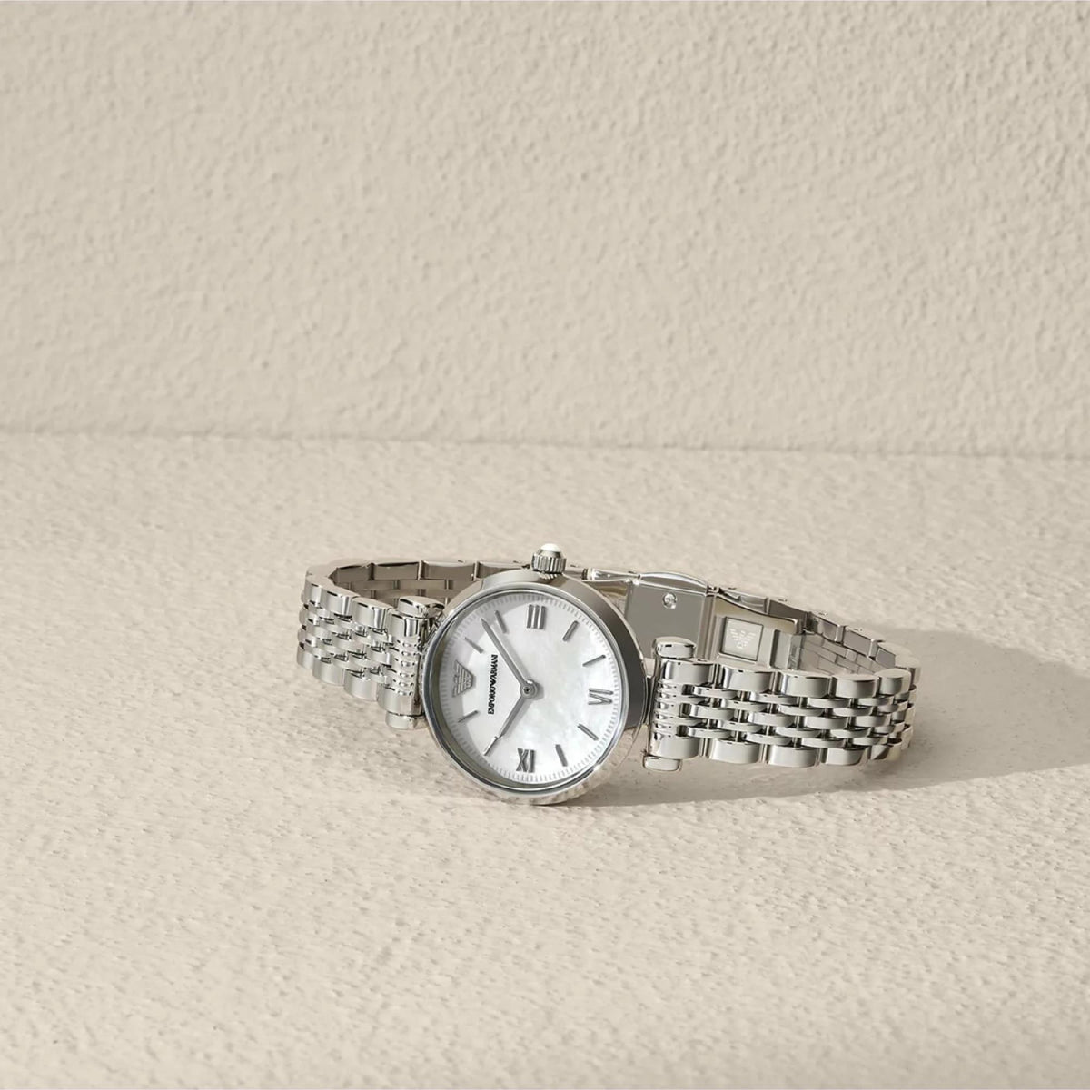 Stainless steel watch with white mother-of-pearl dial and link bracelet, side view