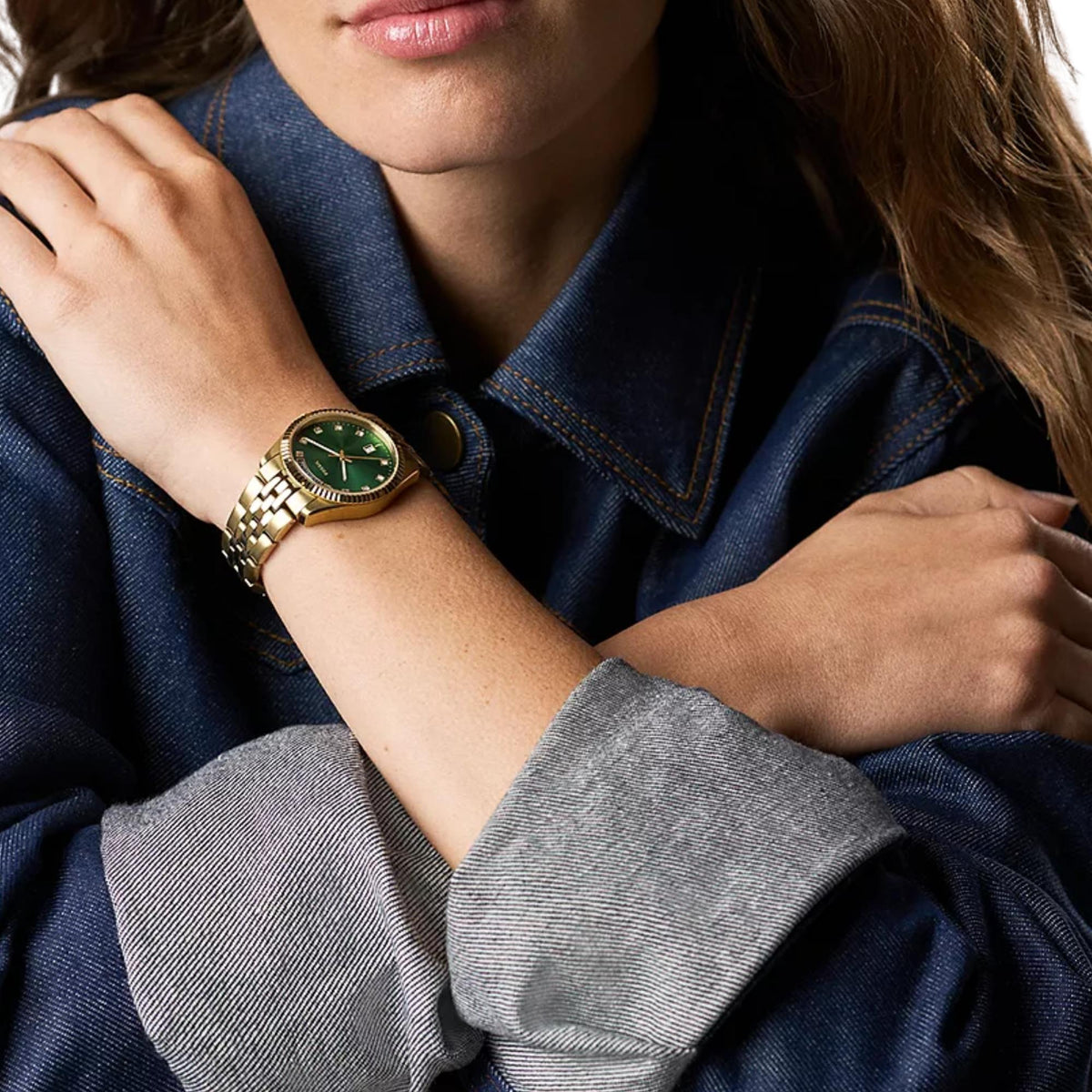 On-wrist view of the Fossil Scarlette ES5460 wristwatch showcasing the green dial with gold-tone link bracelet styled with denim jacket