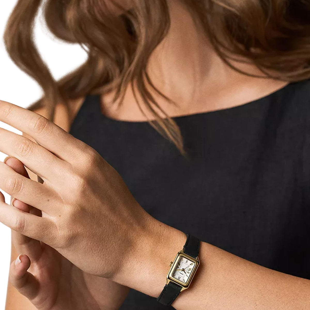 On-wrist view of Fossil Raquel ES5470 ladies timepiece showcasing the white dial, gold-tone casing, and slim black strap