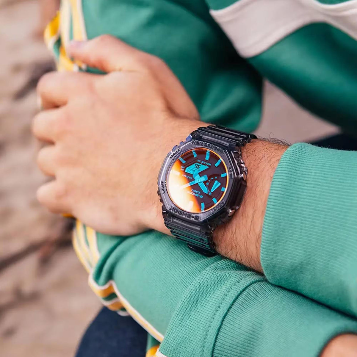 Casio G-Shock GA-2100TLS-8AER on wrist with orange-blue dial and black resin strap, close-up