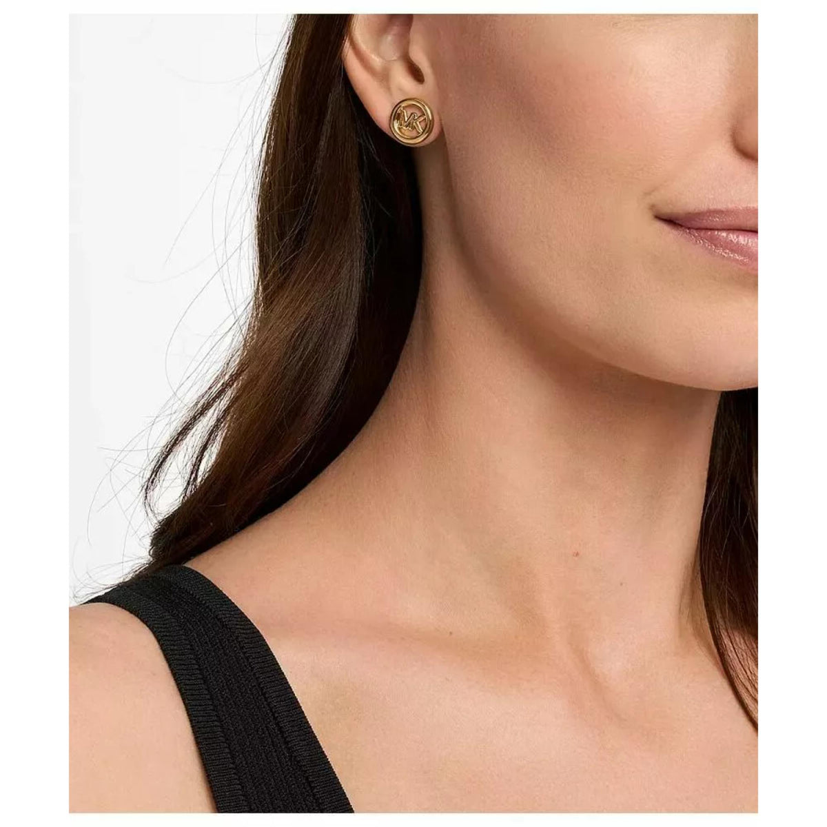Michael Kors gold-tone round stud earrings with MK logo worn on ear