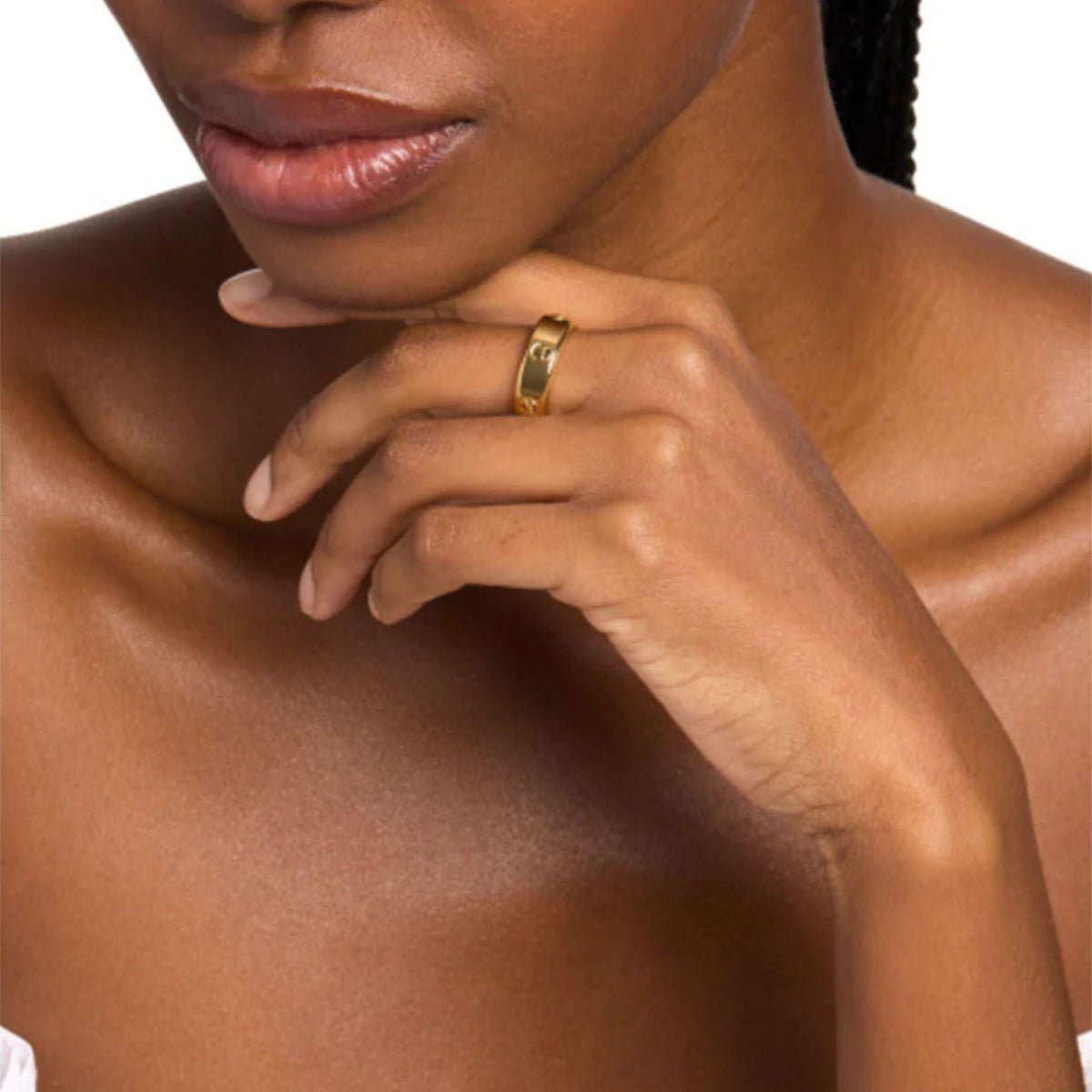 Gold tone Michael Kors ring worn on finger, showing MK logo and cutout design