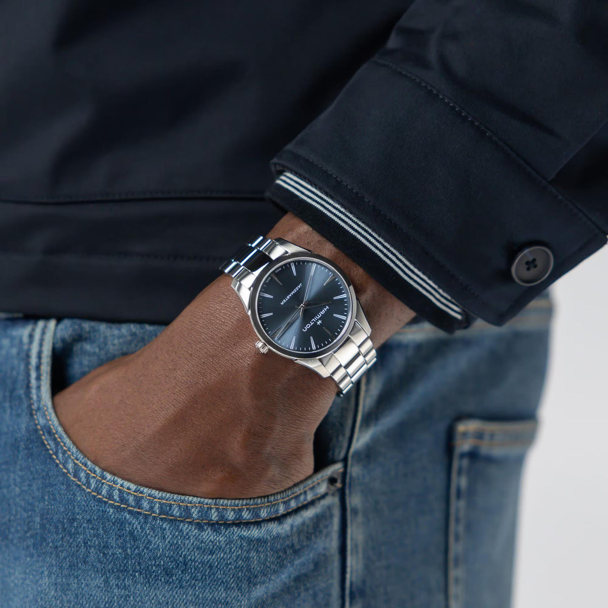 Hamilton Jazzmaster H32461141 wrist shot displaying minimalist dress watch with blue dial and silver bracelet paired with denim jeans