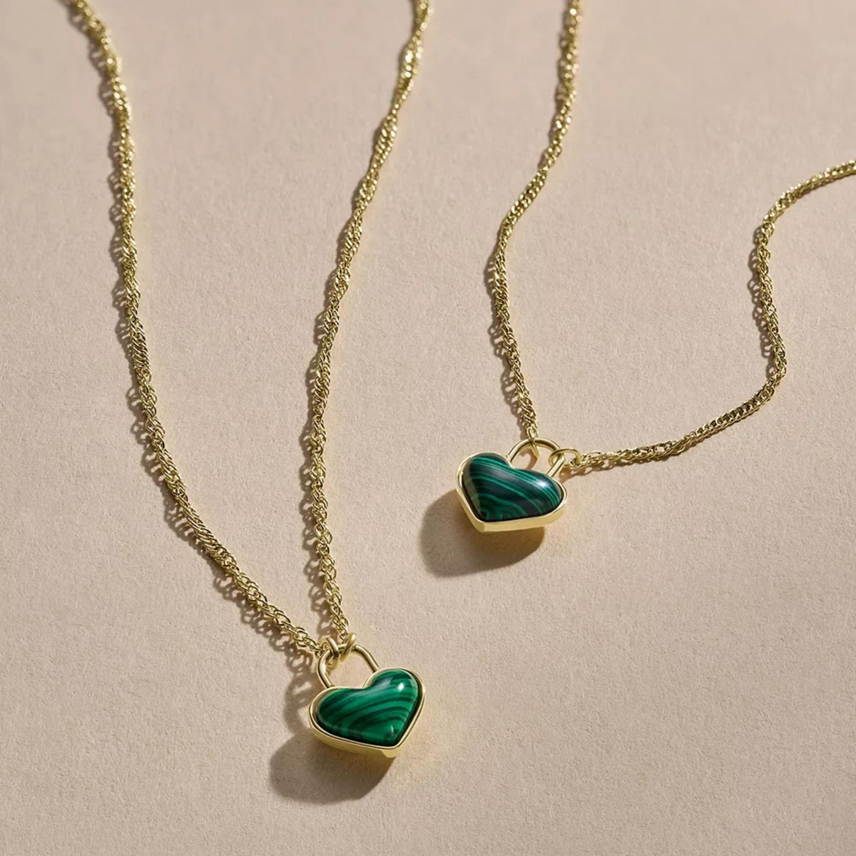 Gold-tone heart charm bracelet with two green marbled heart pendants