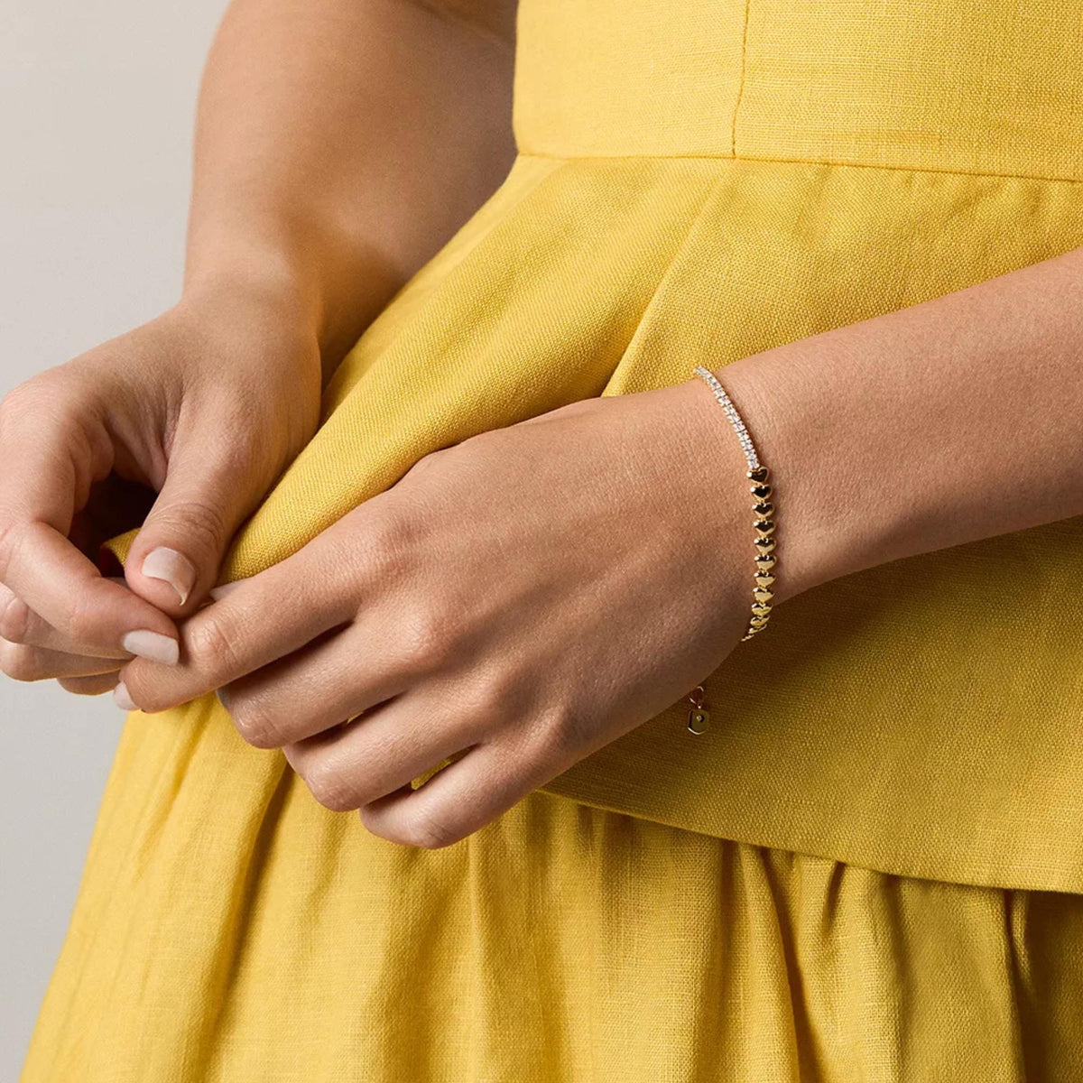 Fossil gold-tone brass heart link tennis bracelet on wrist