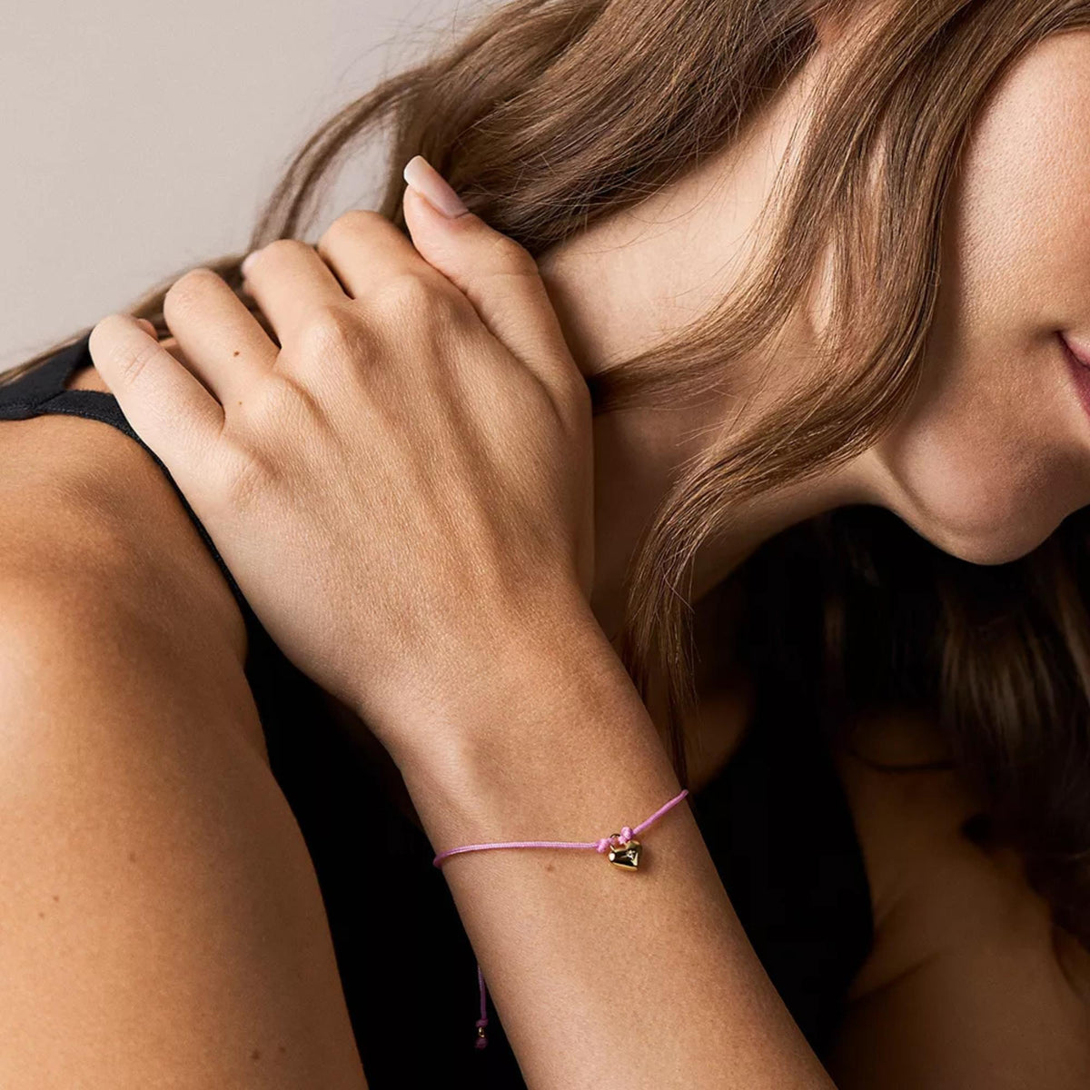 Fossil slim pink bracelet with gold heart charm worn on wrist