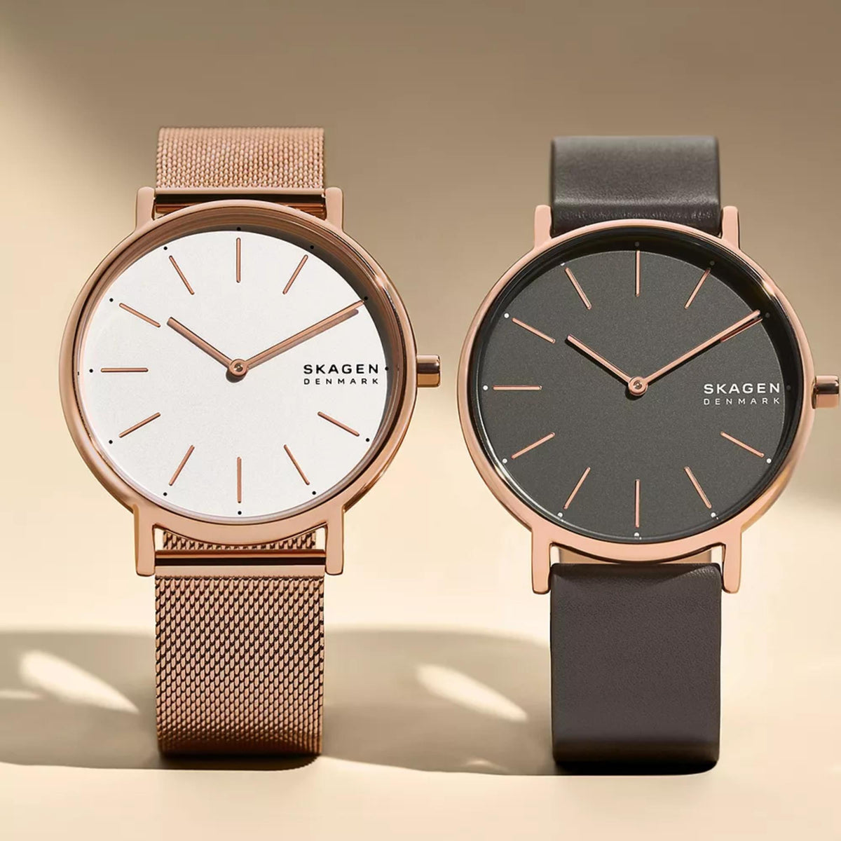 Two rose-gold case leather watches with round dials and charcoal and white faces