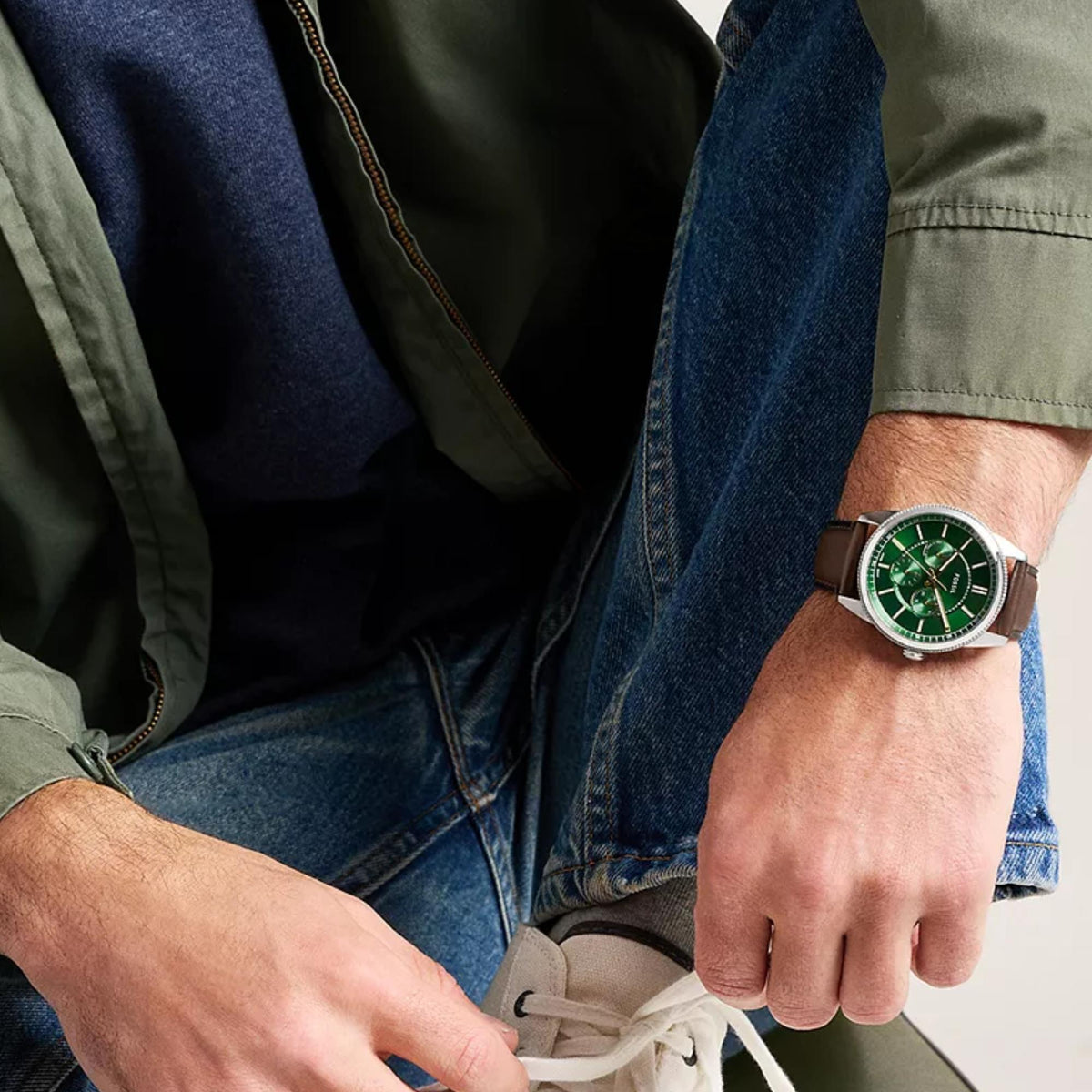 On-wrist view of Fossil Pearson FS6137 mens chronograph showcasing the green dial, gold accents, and brown leather strap