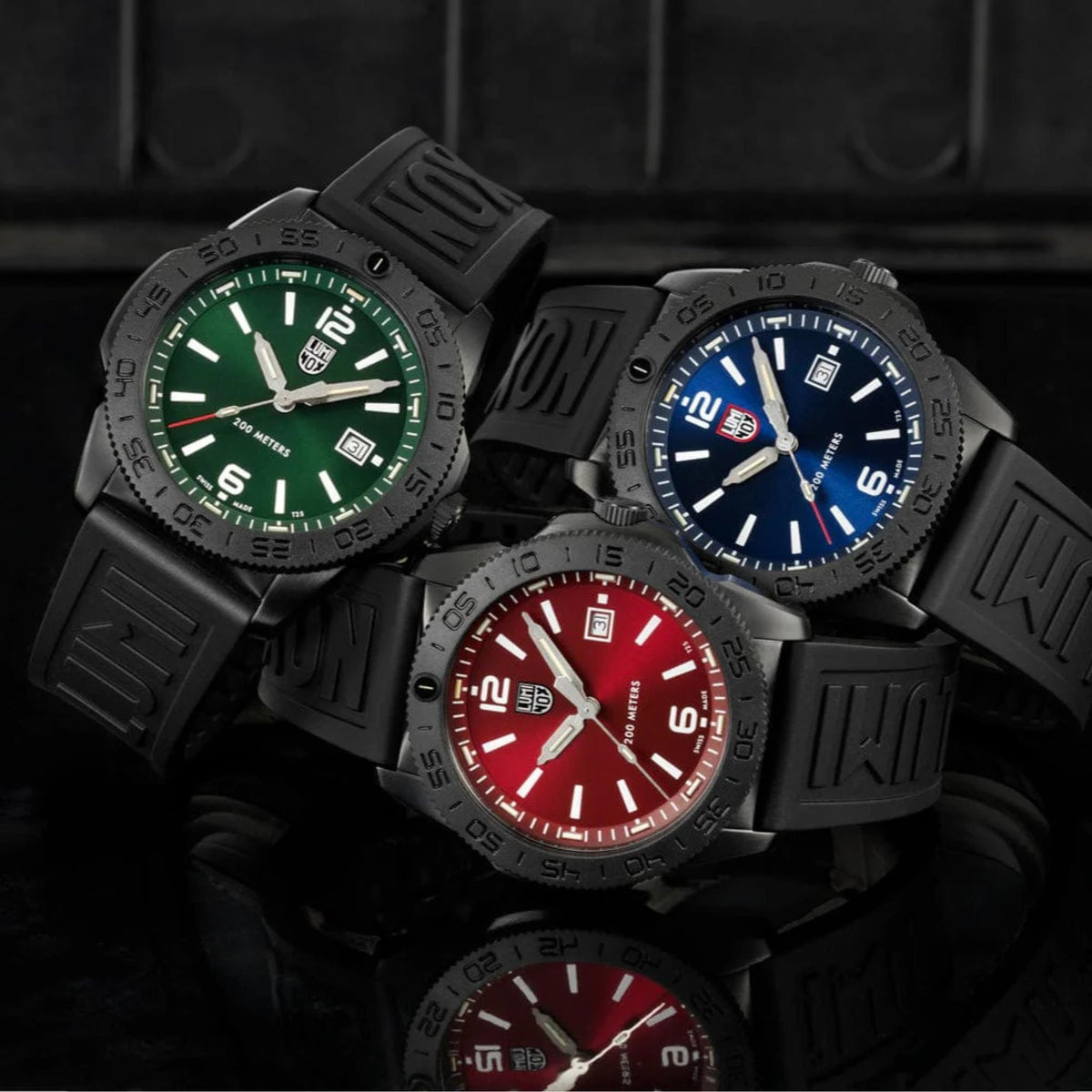 Three Luminox Pacific Diver 44mm quartz watches with blue, green, and red dials