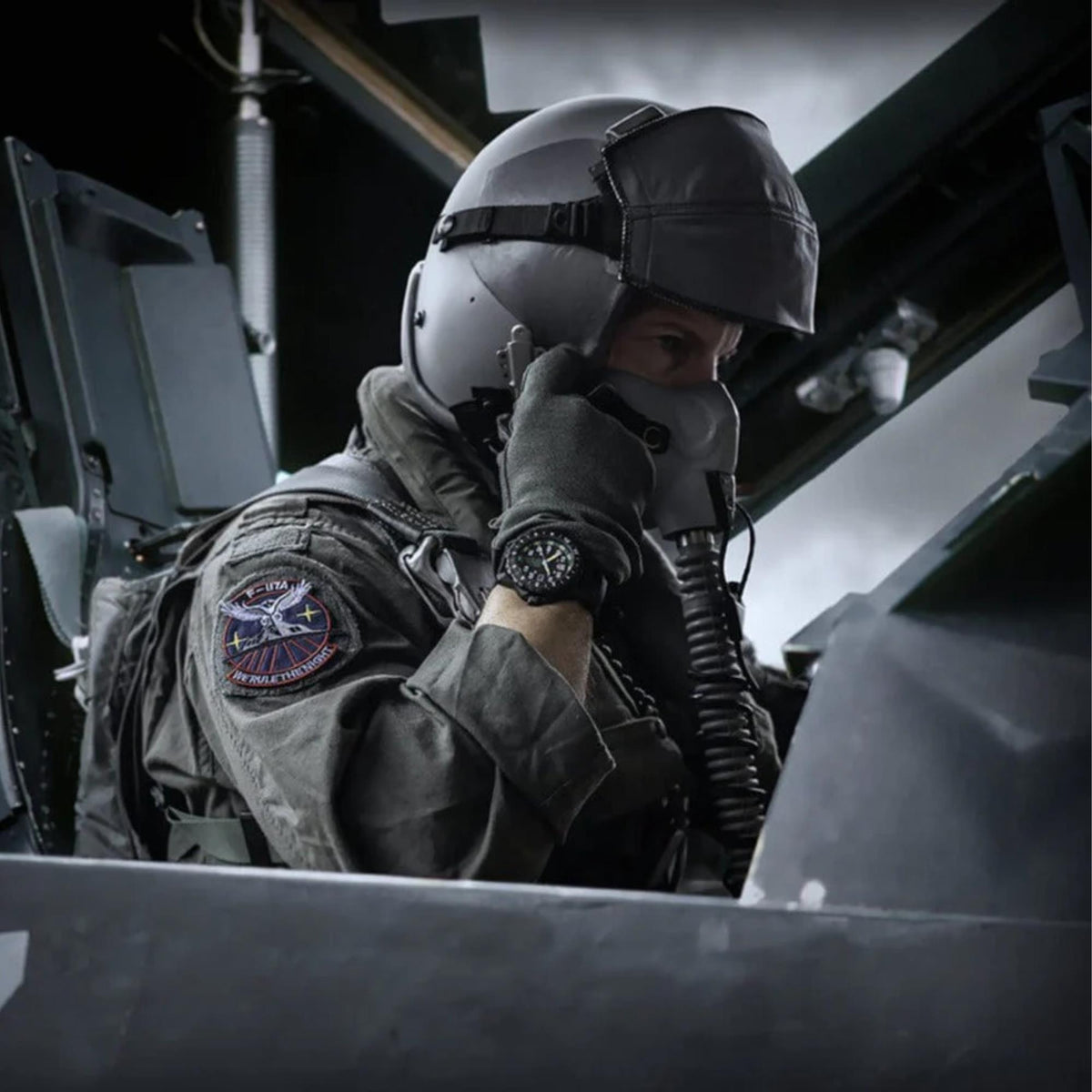Fighter pilot seated in a cockpit wearing an oxygen helmet and the Luminox F-117 Nighthawk XA.6442.H aviator timepiece