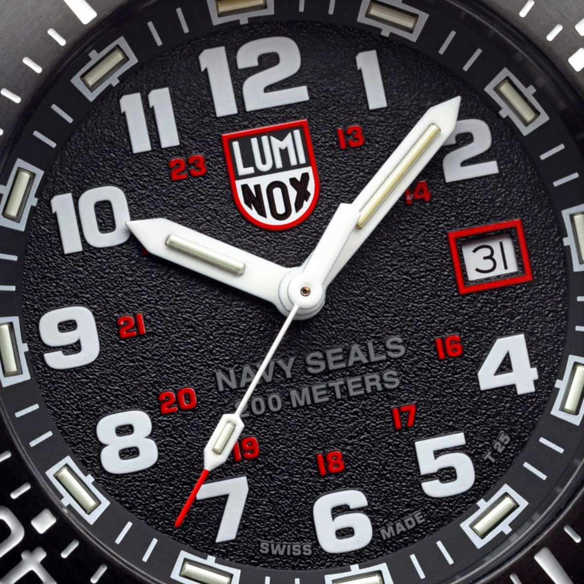 Close-up of black dial with red Luminox NOX logo, luminous hands, and date window