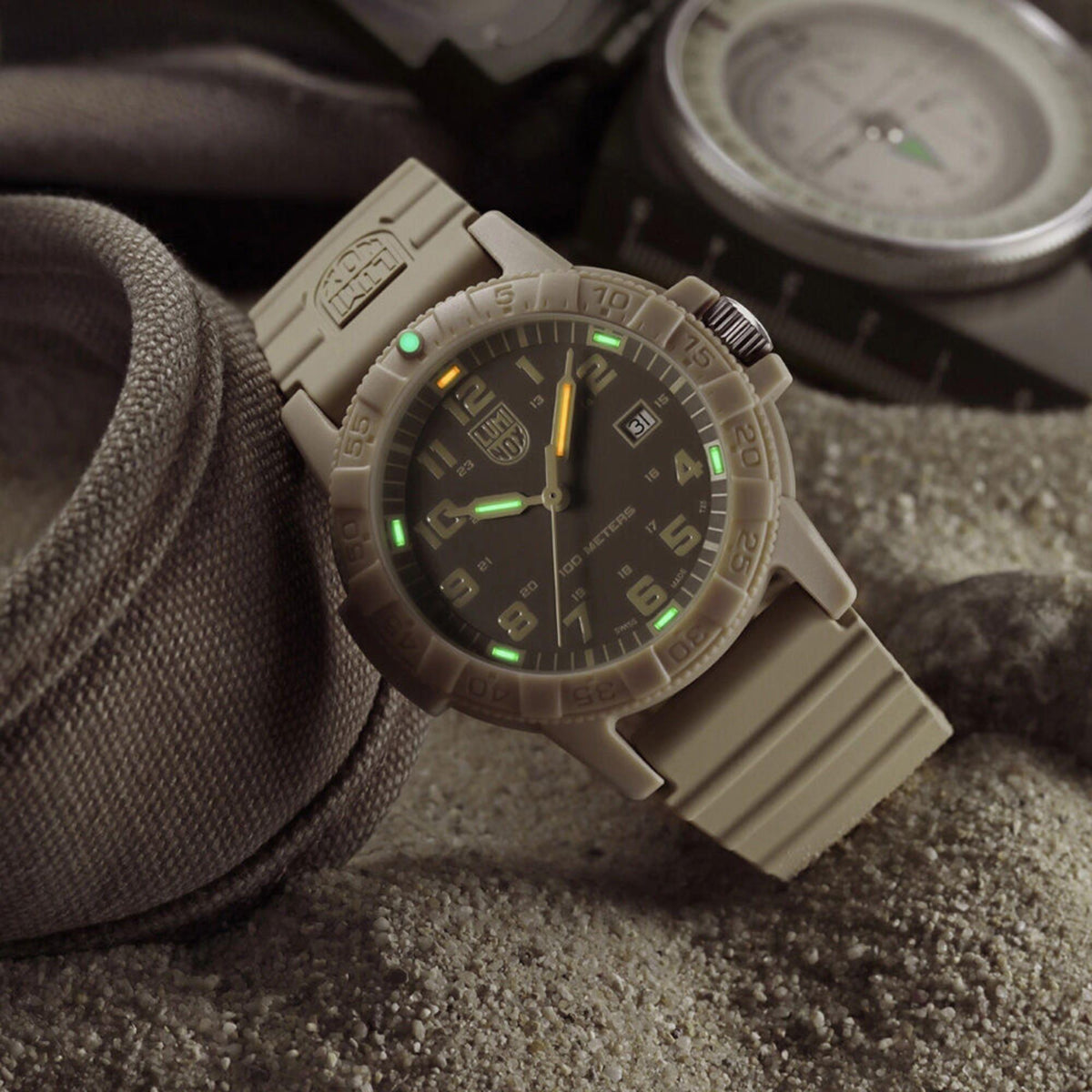 Tactical Luminox Leatherback Sea Turtle XS.0326 watch resting on sand with its green and orange tritium night vision tubes glowing