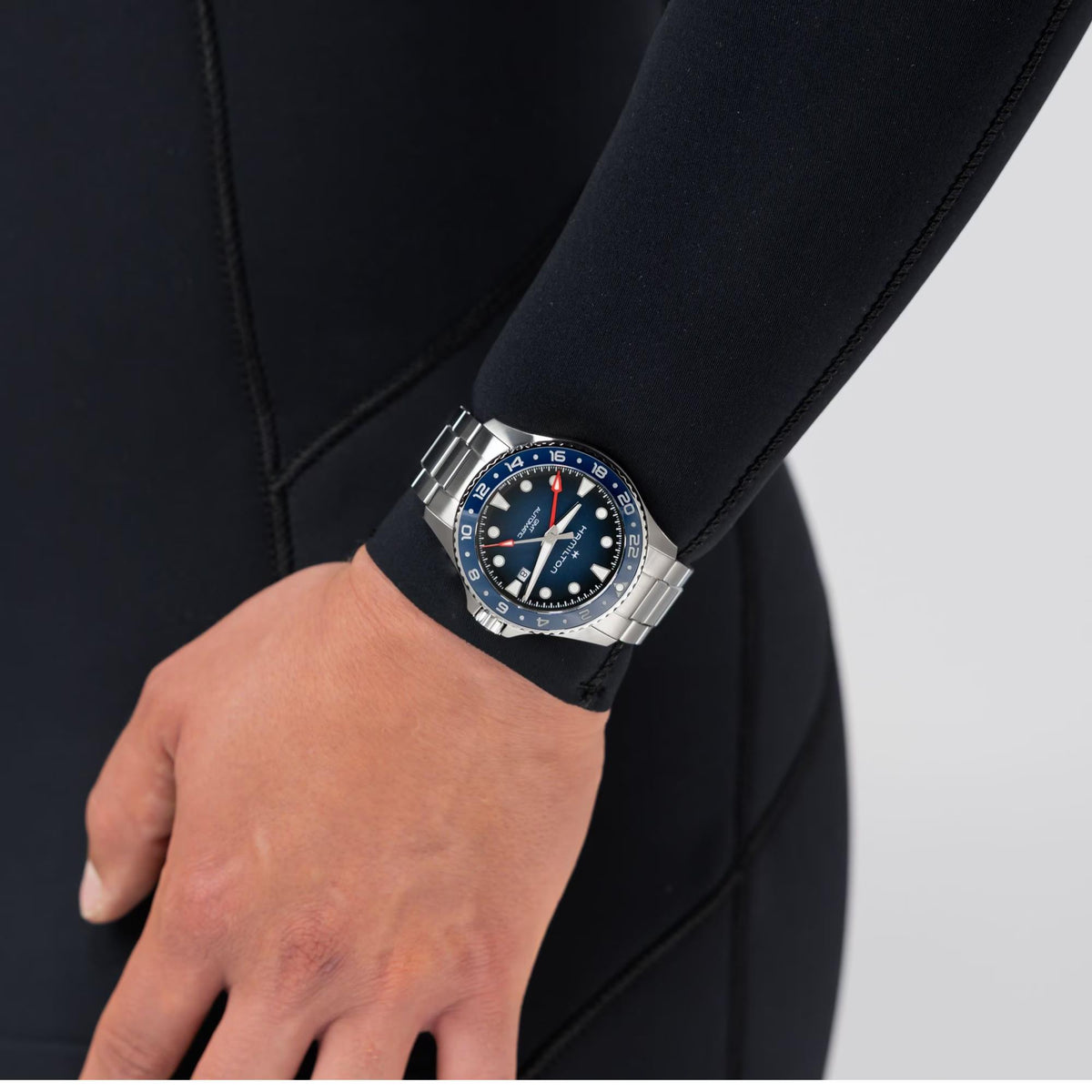 Men's GMT watch with blue dial and rotating bezel worn on a black strap