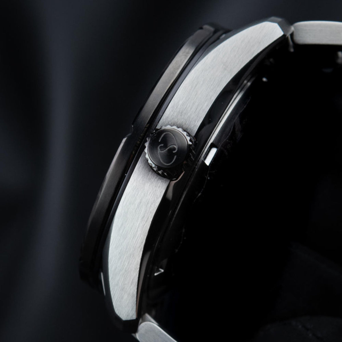 Men's automatic watch case side view, brushed steel finish with crown detail.