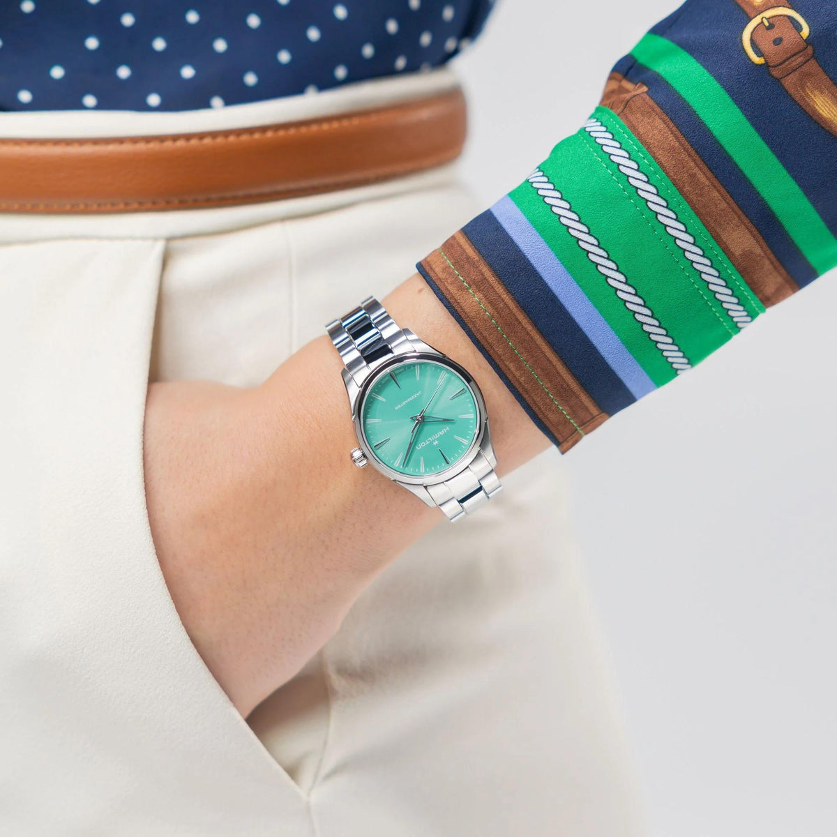 Ladies steel quartz watch on wrist with light green dial and silver bracelet