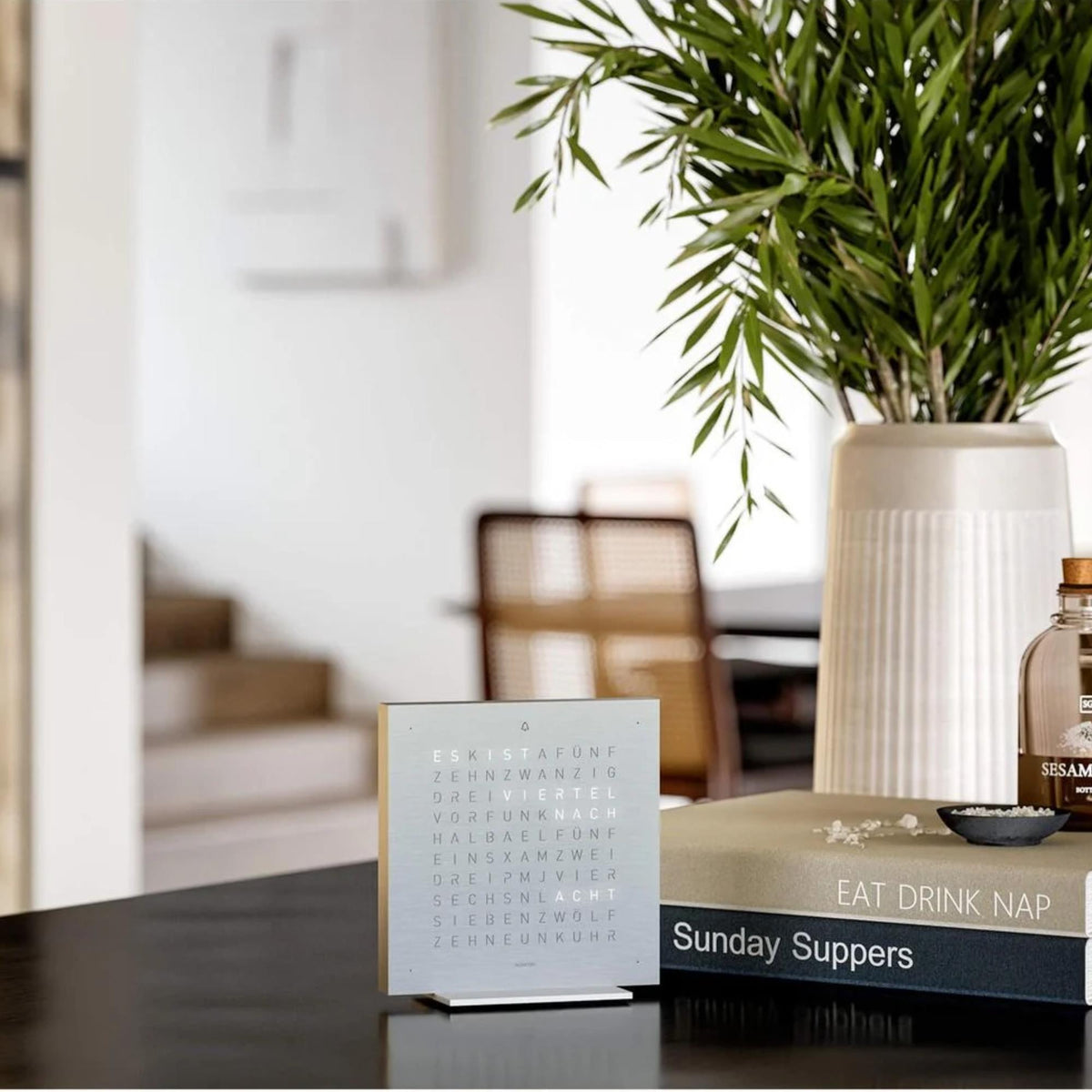 Steel table clock on countertop with English word time display