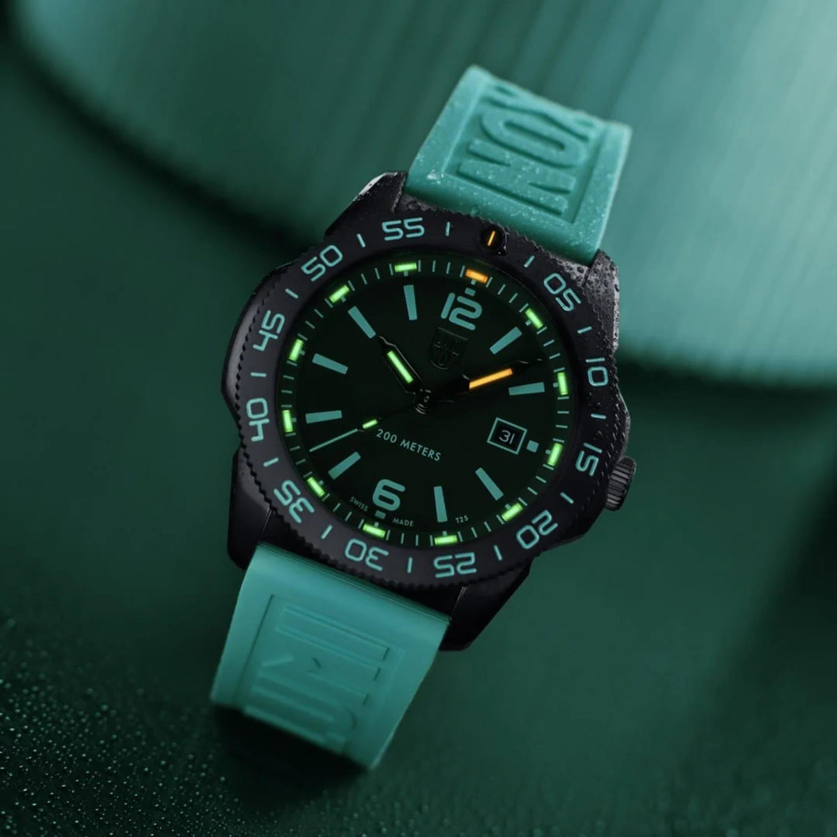 Darkened view displaying the glowing green and orange tritium night sight tubes on the Luminox Pacific Diver XS.3124.N.SET diver watch
