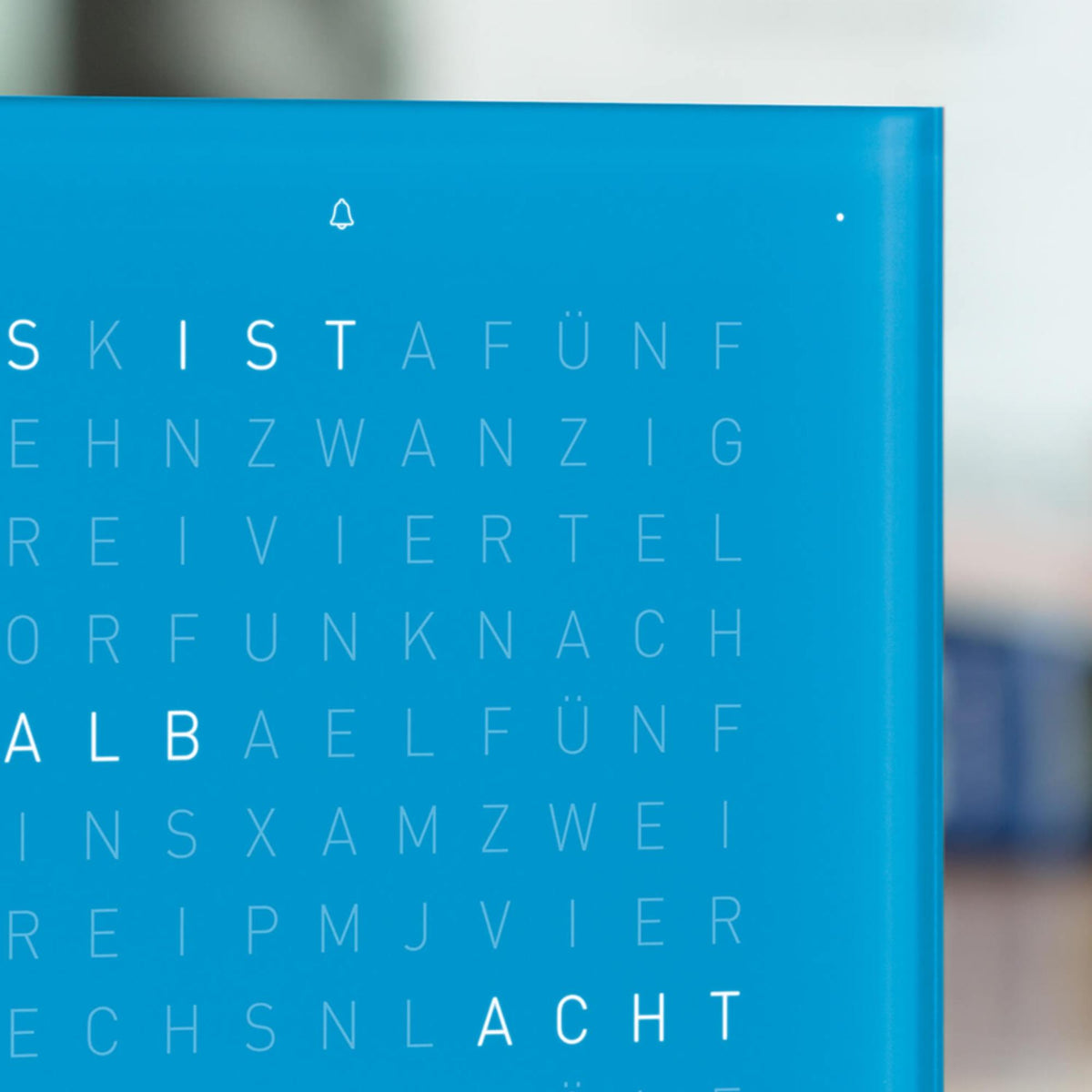 Blue QLOCKTWO table clock display close-up with letter grid and small symbols